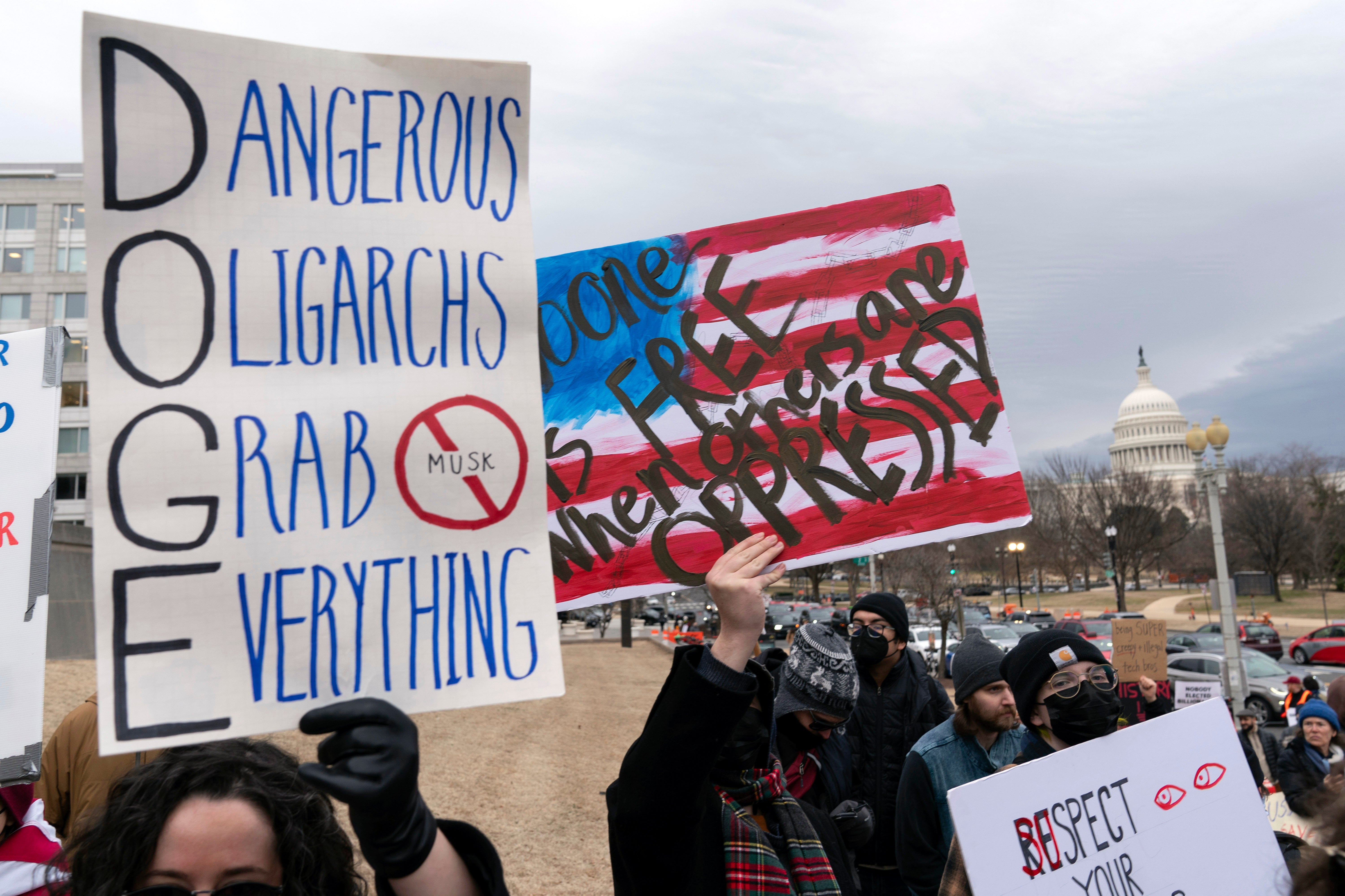 People protest during a rally against Elon Musk outside the U.S. Department of Labor in Washington, Wednesday, Feb. 5,