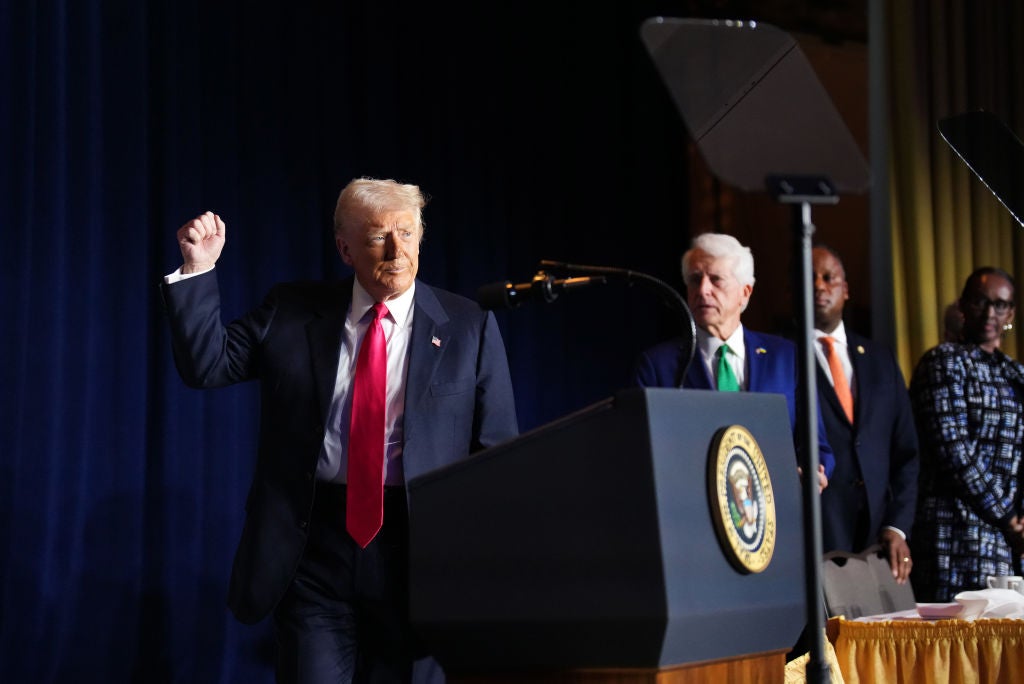 Donald Trump raises his fist to supporters at the National Prayer Breakfast.
