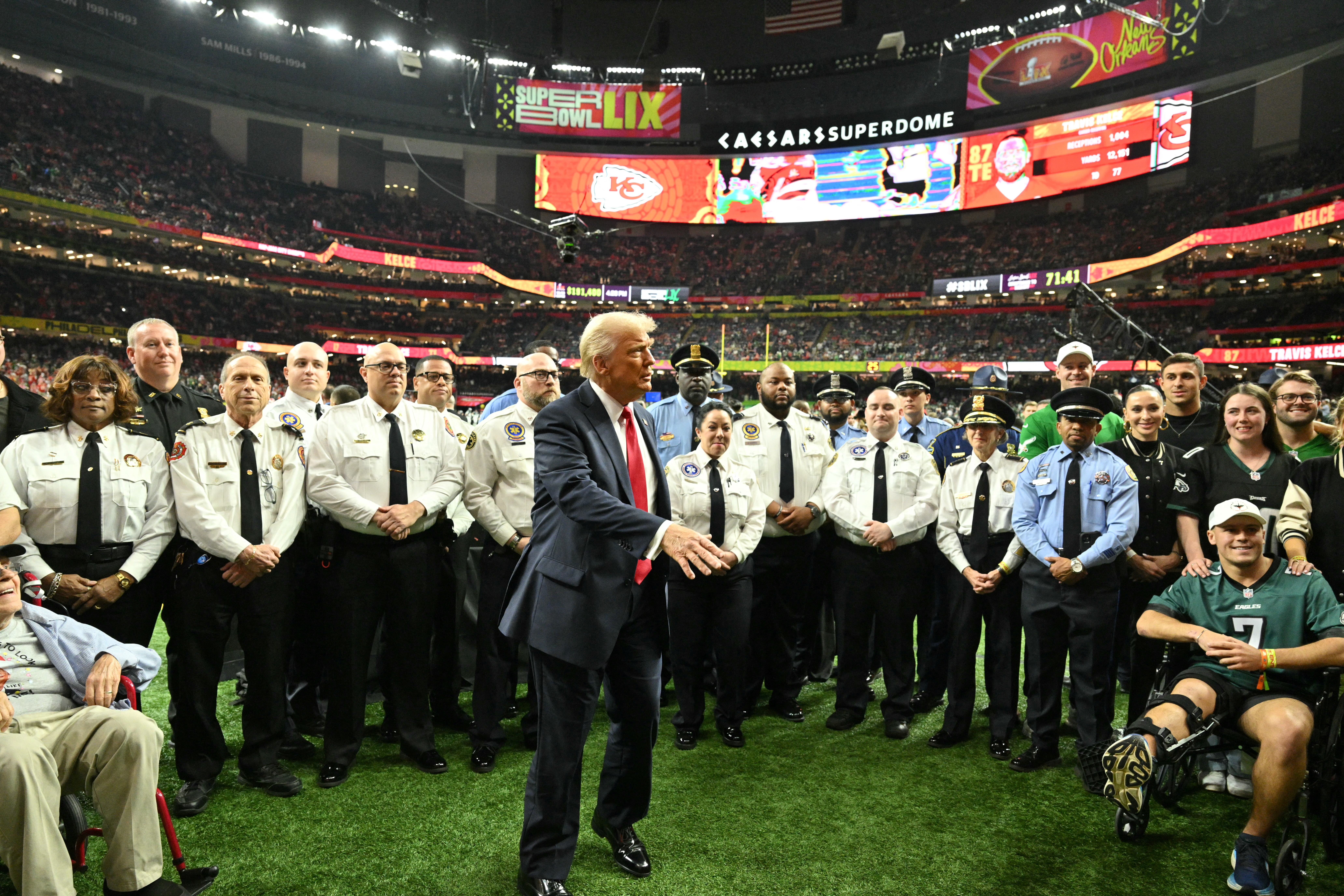 President Donald Trump poses with New Orleans law enforcement officers and victims of the New Year's Day attack as he visits the field before the start of Super Bowl LIX between the Kansas City Chiefs and the Philadelphia Eagles at Caesars Superdome in New Orleans, Louisiana, February 9, 2025