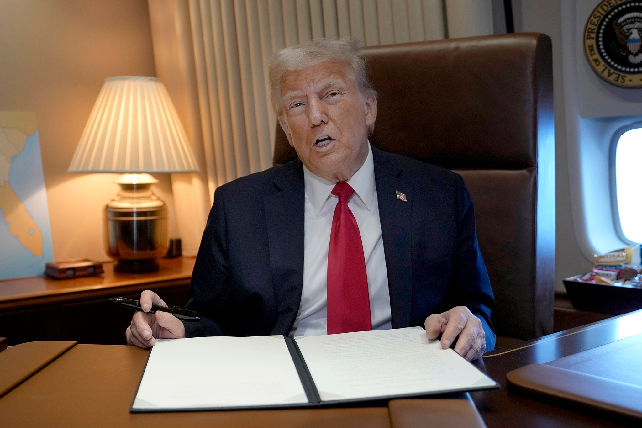 US president Donald Trump talks to journalists aboard Air Force One