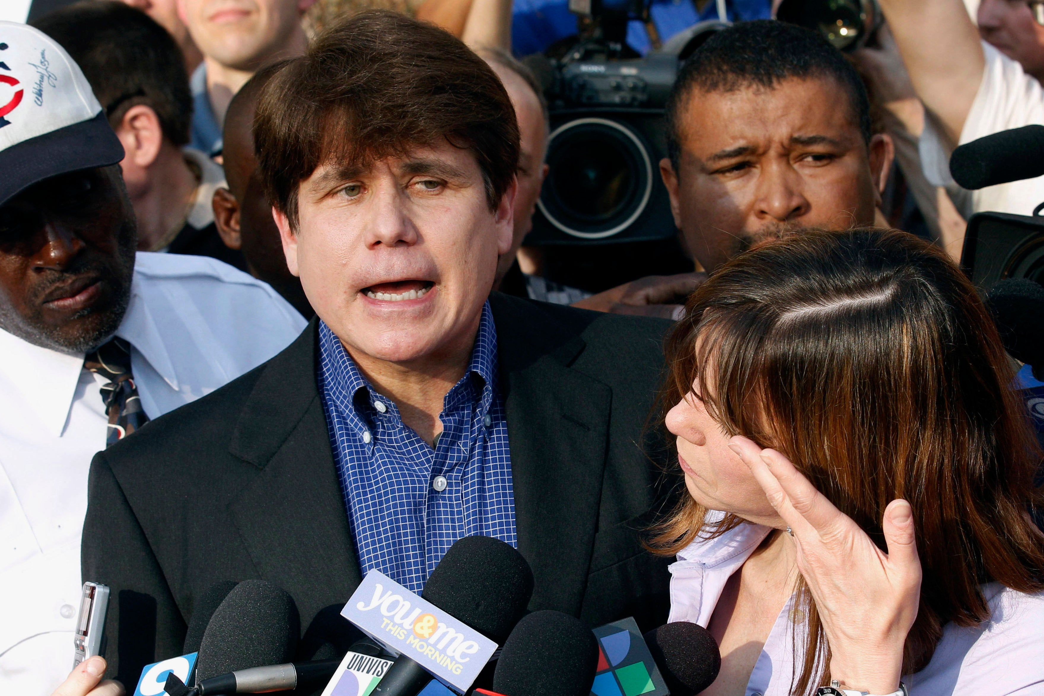 Blagojevich speaks to the media outside his home in Chicago as his wife, Patti, wipes away tears a day before reporting to prison after his conviction on corruption charges