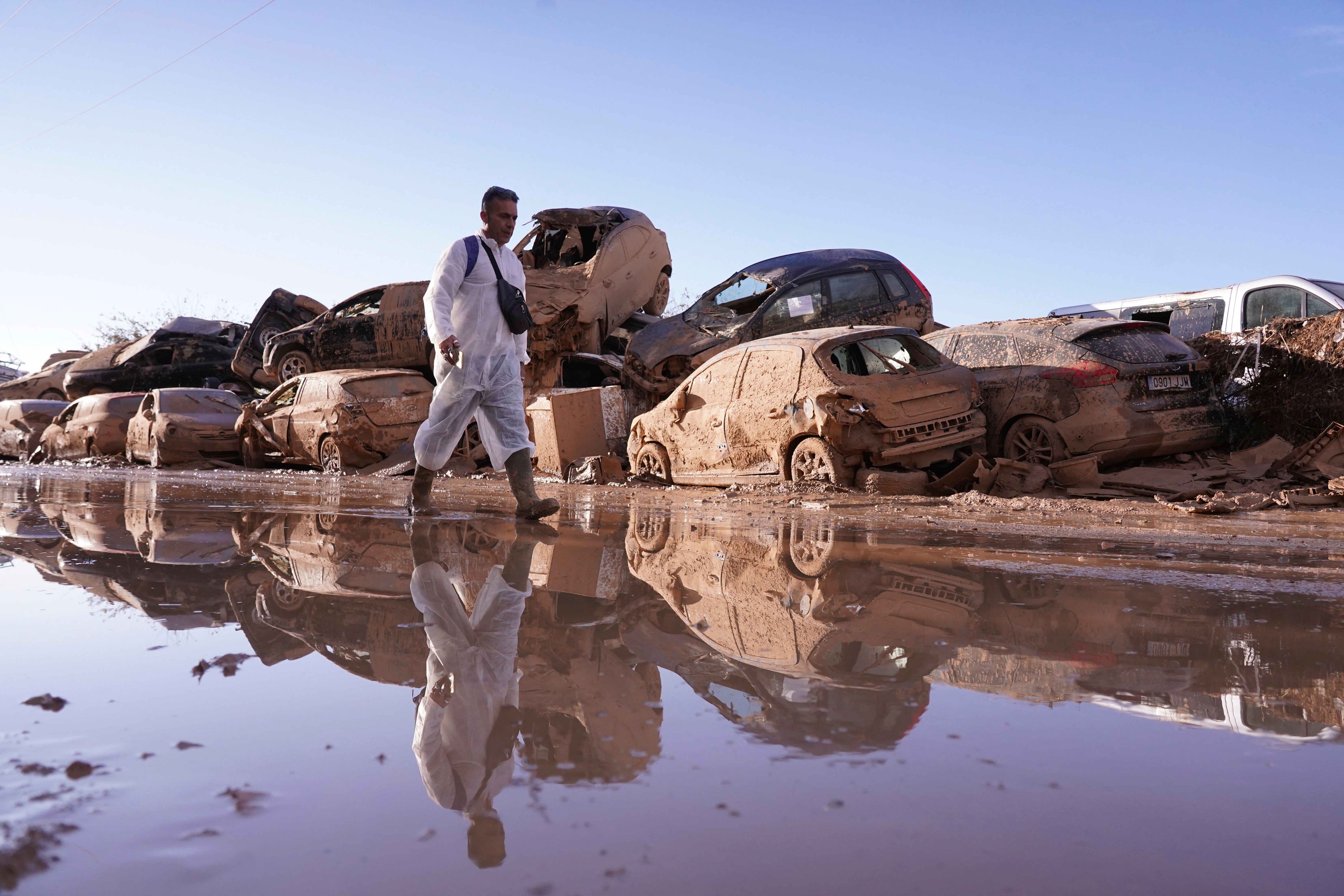 File. A man walks past cars damaged by floods in Catarroja in Spain’s Valencia region on 12 November 2024