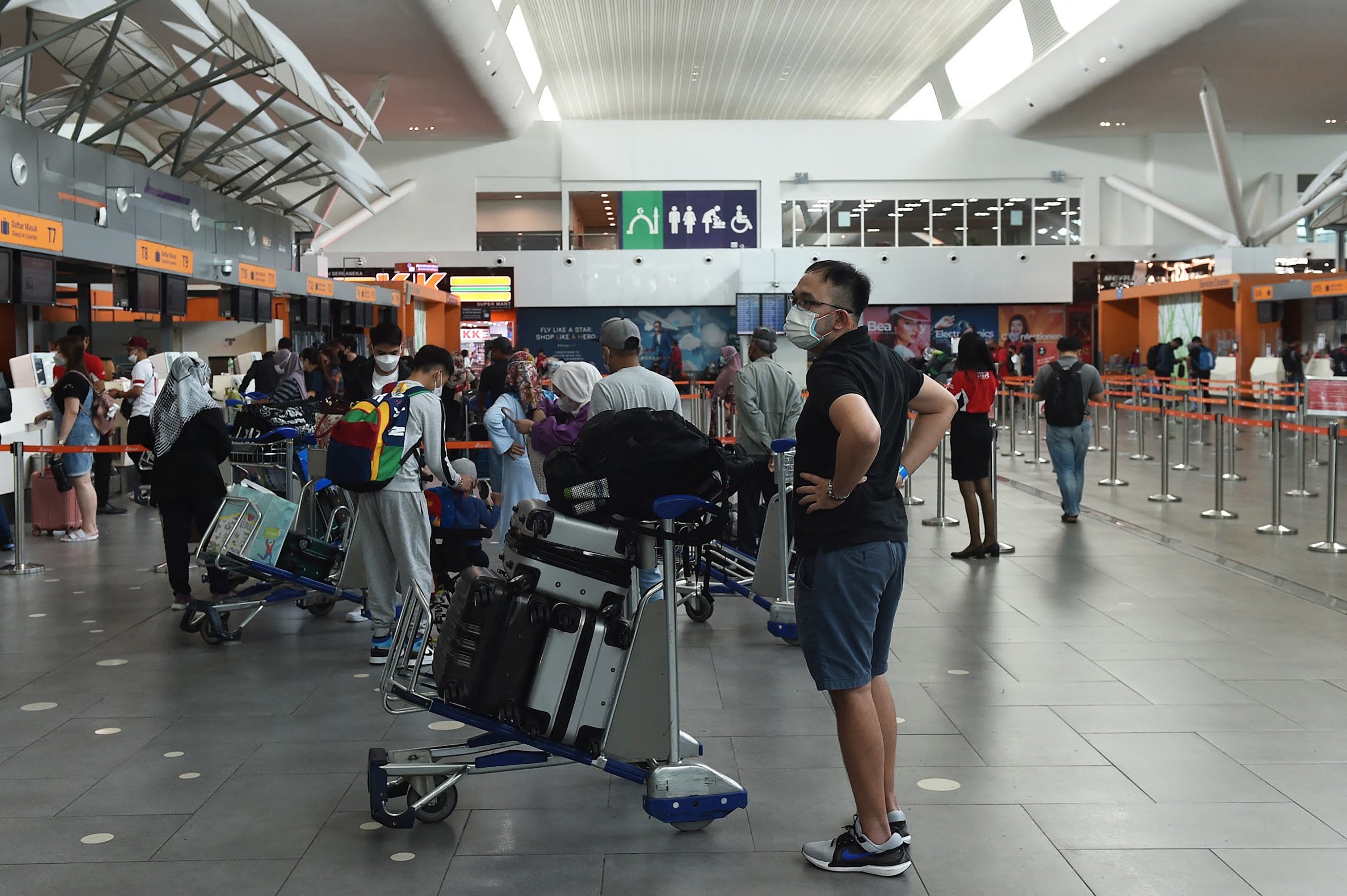 File. Passengers wait in line to drop off their luggage ahead of their departure at the Kuala Lumpur International Airport's low-cost terminal in Sepang