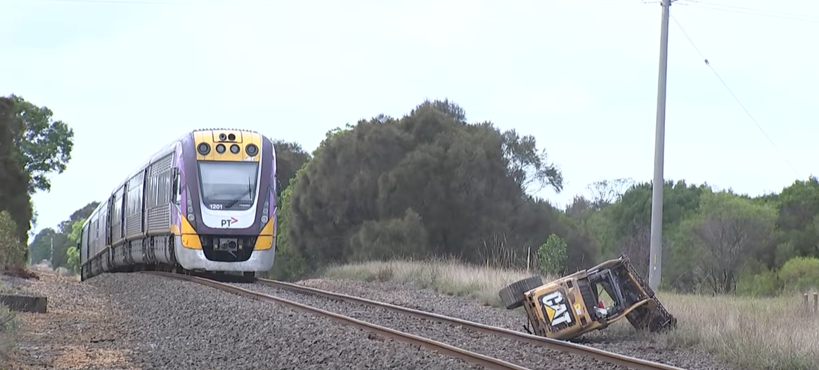 A truck carrying an excavator on a trailer struck a passenger train