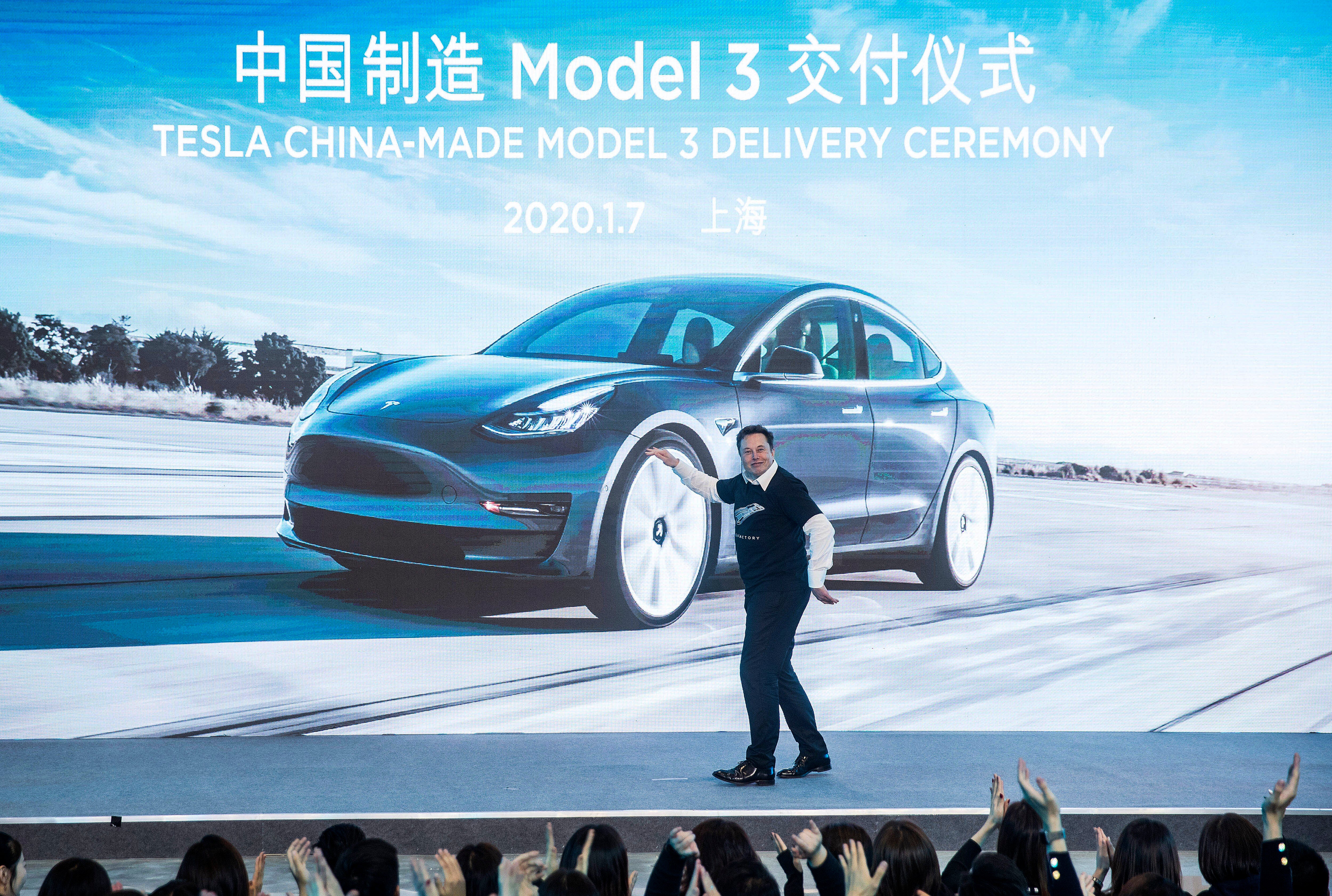 In this photo released by China’s Xinhua News Agency, Tesla CEO Elon Musk reacts at a delivery ceremony