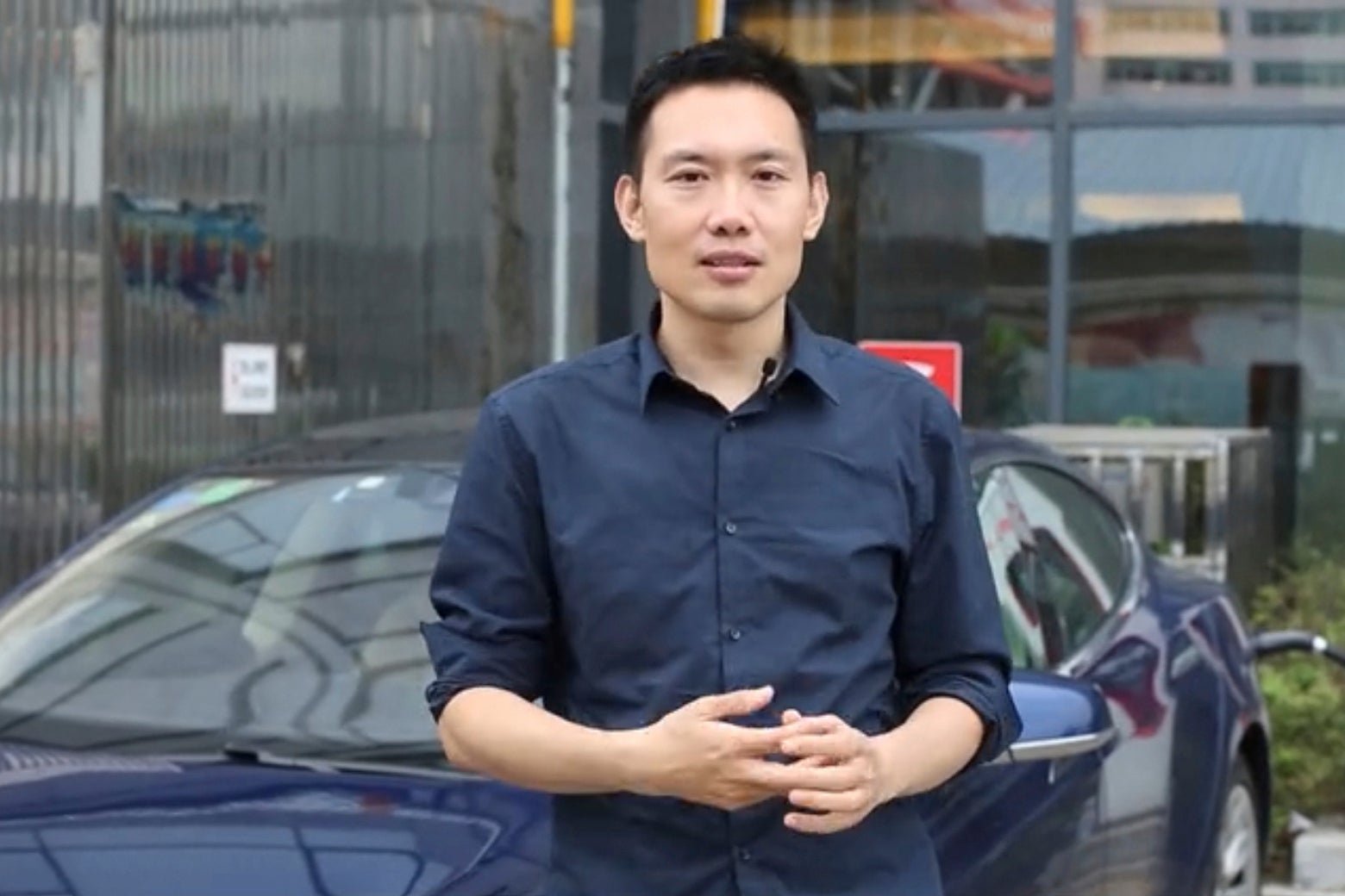 In this image from social media video provided by Feng Shiming, he talks about Tesla standing in front of a Model S that he owns, in Yangzhou, China, in October 2017. (Feng Shiming via AP)