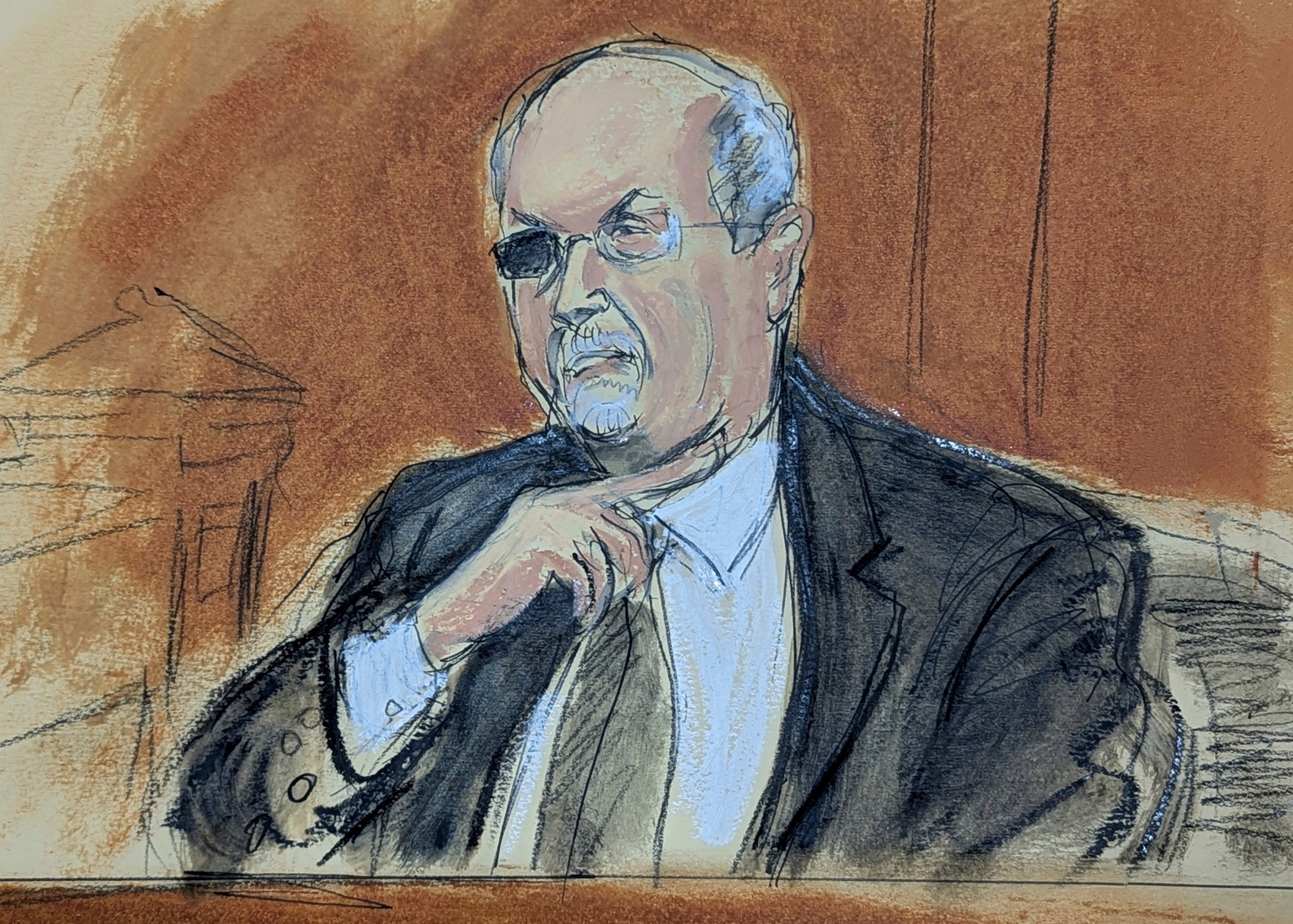 Salman Rushdie testifies on the witness stand gesturing how the attacker slashed his throat when he was attacked at the Chautauqua Institute