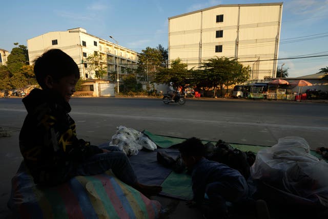 <p>File A boy plays near a building, where people trafficked under false pretenses are forced to work in online scams targeting people all over the world, in Phnom Penh, Cambodia</p>