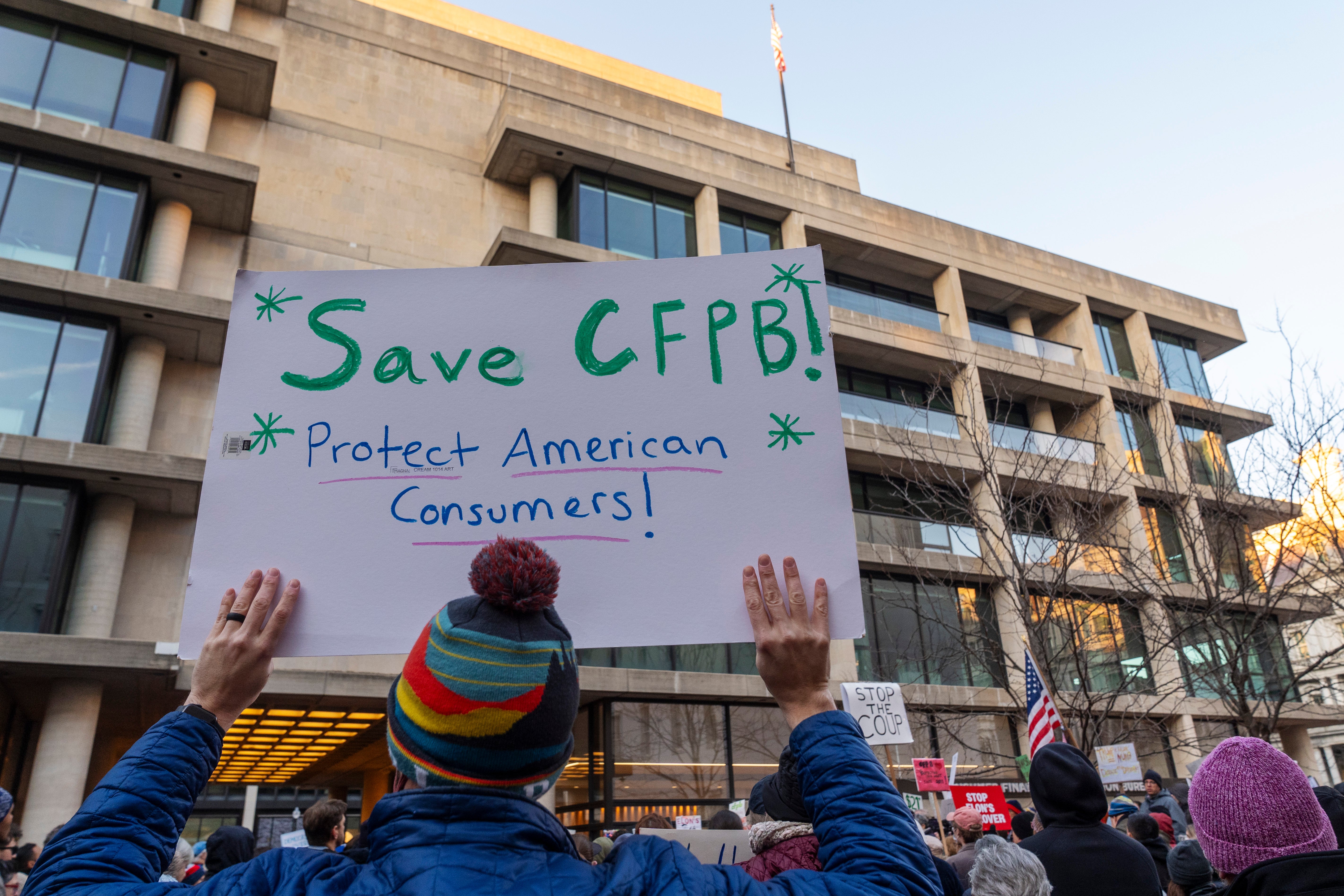 Protesters rally against the closure of the Consumer Financial Protection Bureau, which has become the latest target of Donald Trump and Elon Musk’s cost-cutting. A pastor is now the only named plaintiff in a lawsuit over the organization’s closing
