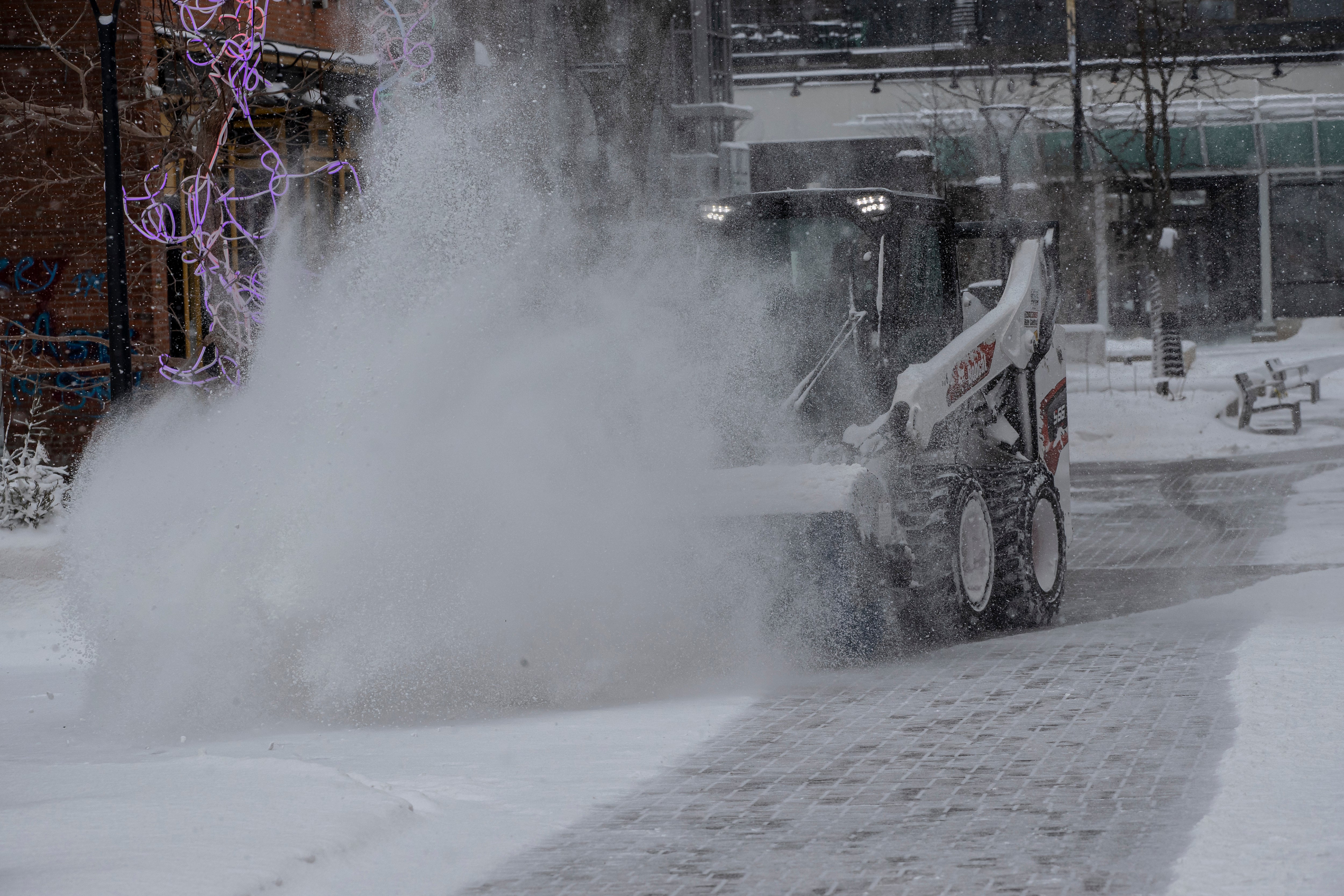 City workers clear snow from the pedestrian mall in Iowa City
