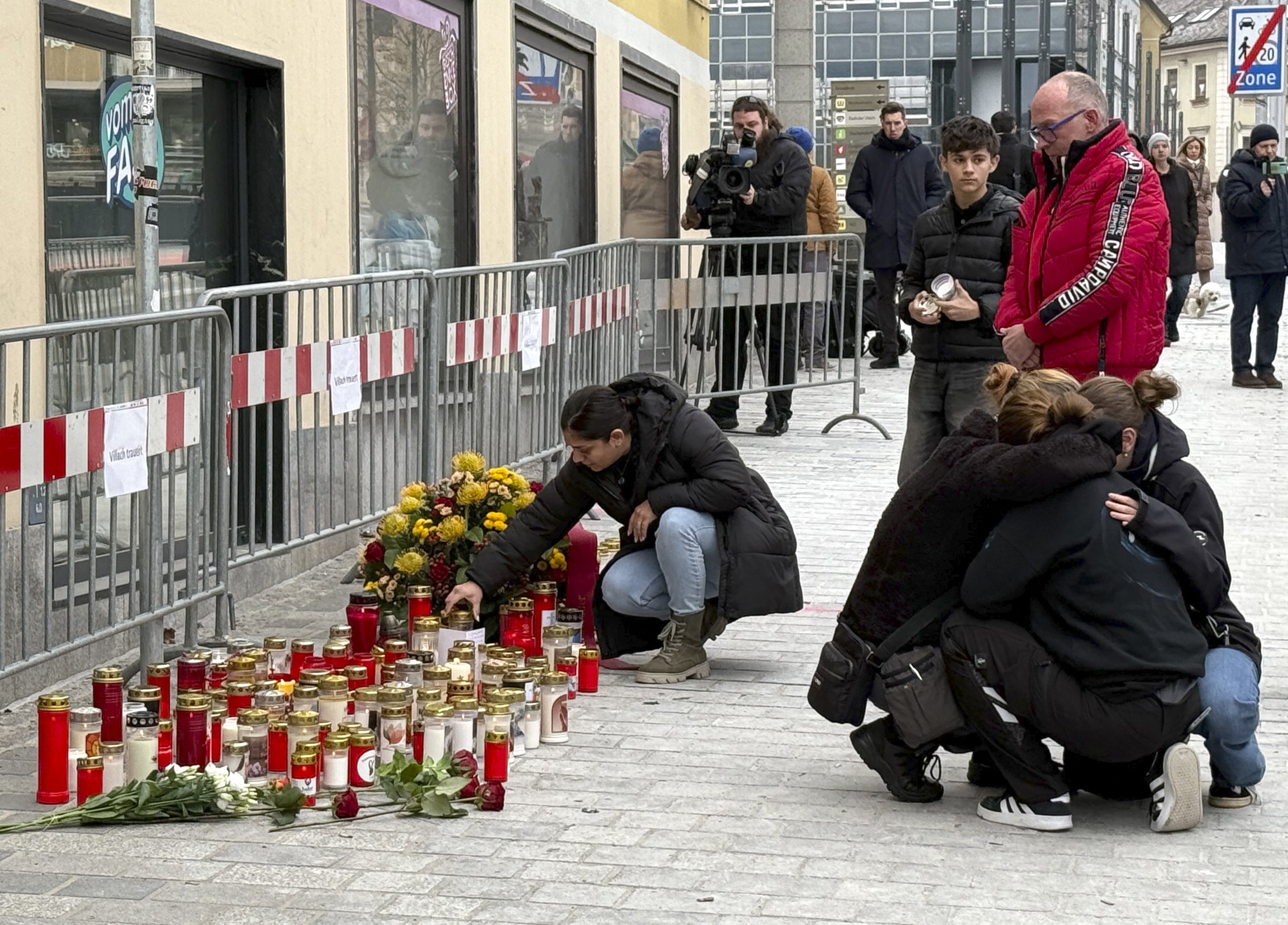 People mourn at a makeshift memorial of candles and flowers
