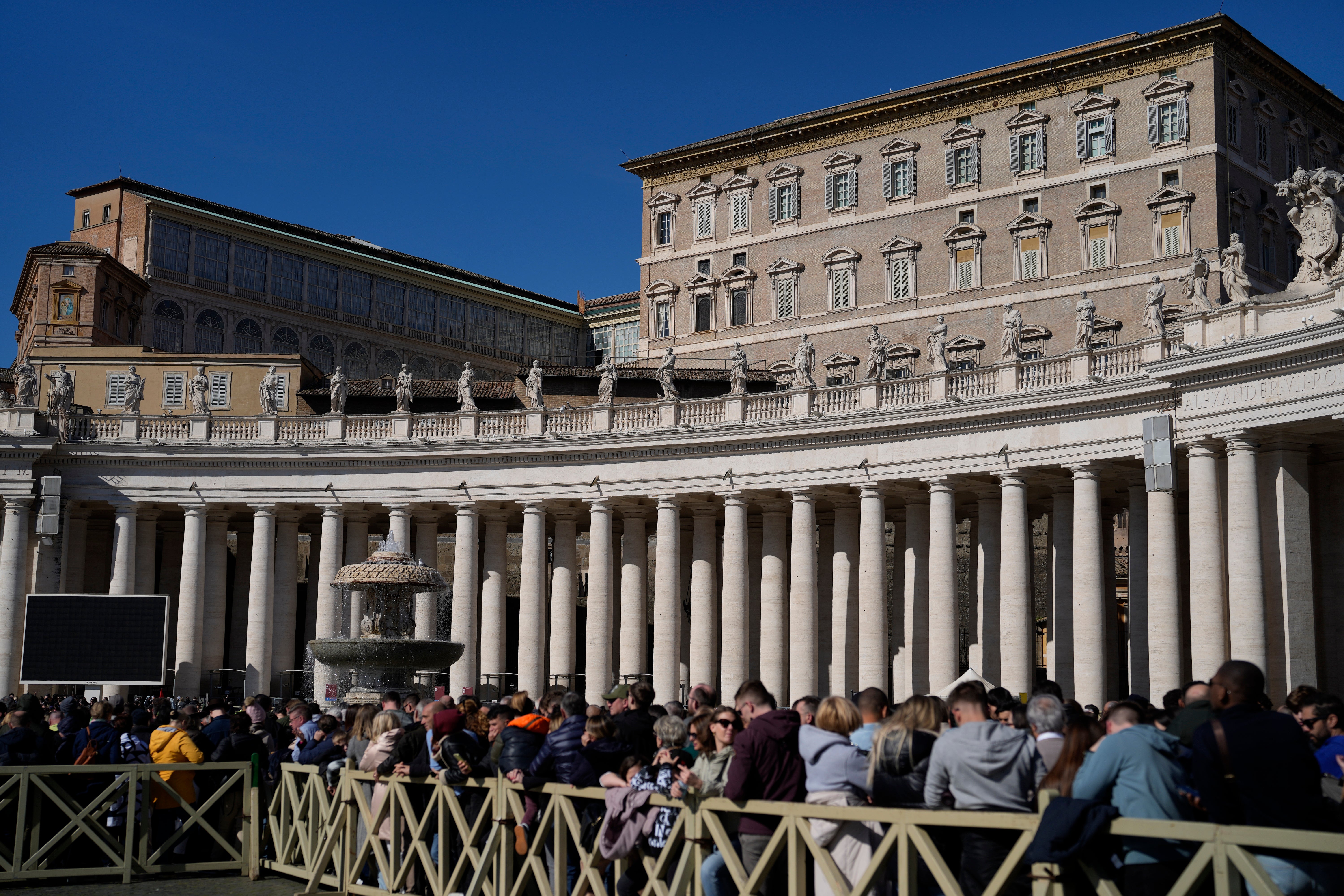 Faithful wait under the closed window of the Apostolic Palace at The Vatican, where the Pope blesses the faithful every Sunday