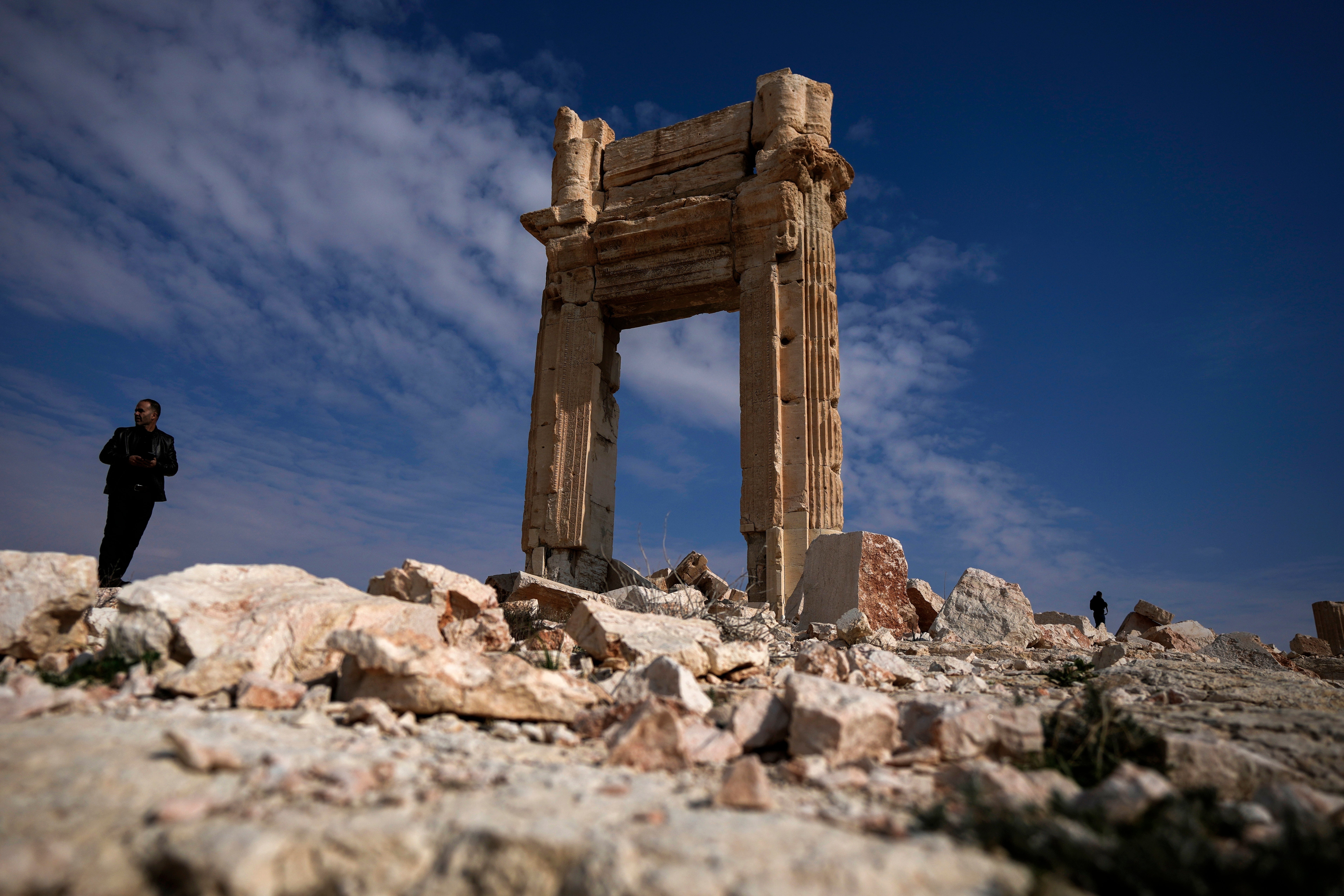 Two men stand on the ruins of the Temple of Bal, which was destroyed by ISIS in 2015, at the ancient city of Palmyra