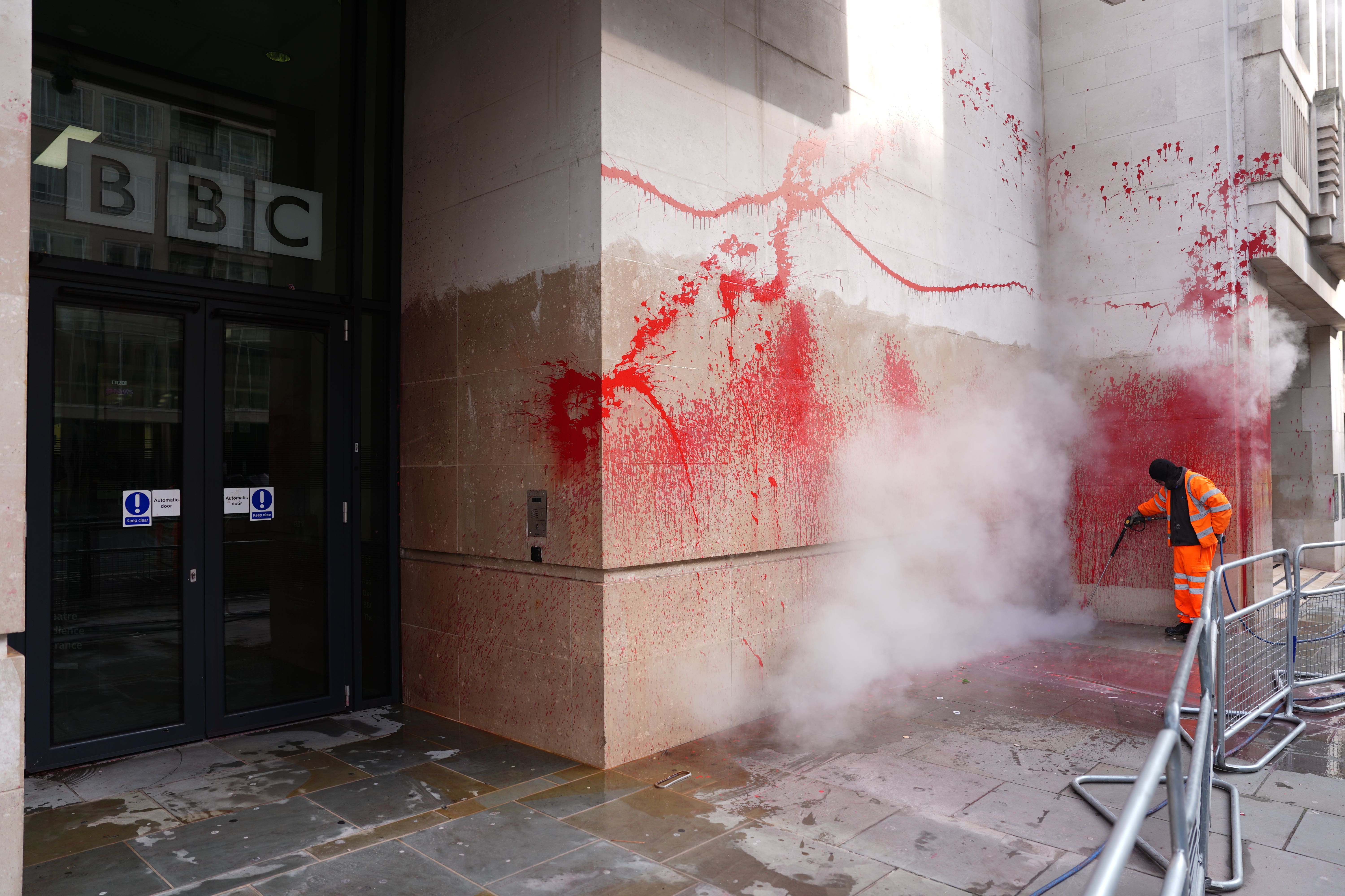 A worker cleans paint from the walls of the BBC building which was targeted in the early hours of Monday (Jordan Pettitt/PA)