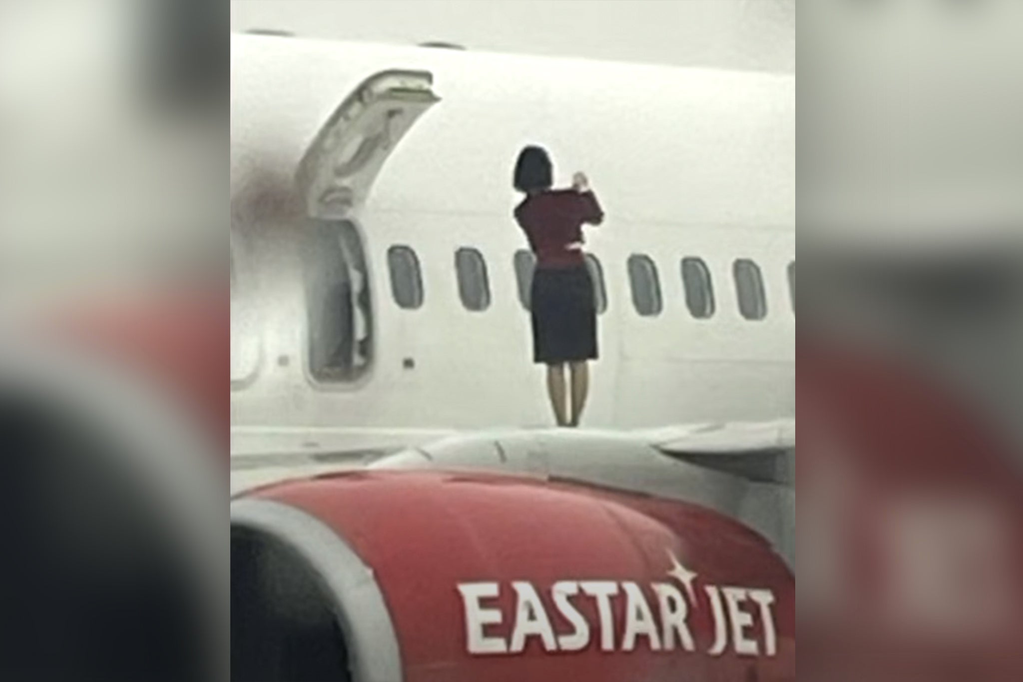 Flight attendants were seen walking on the plane wing and appearing to take photos