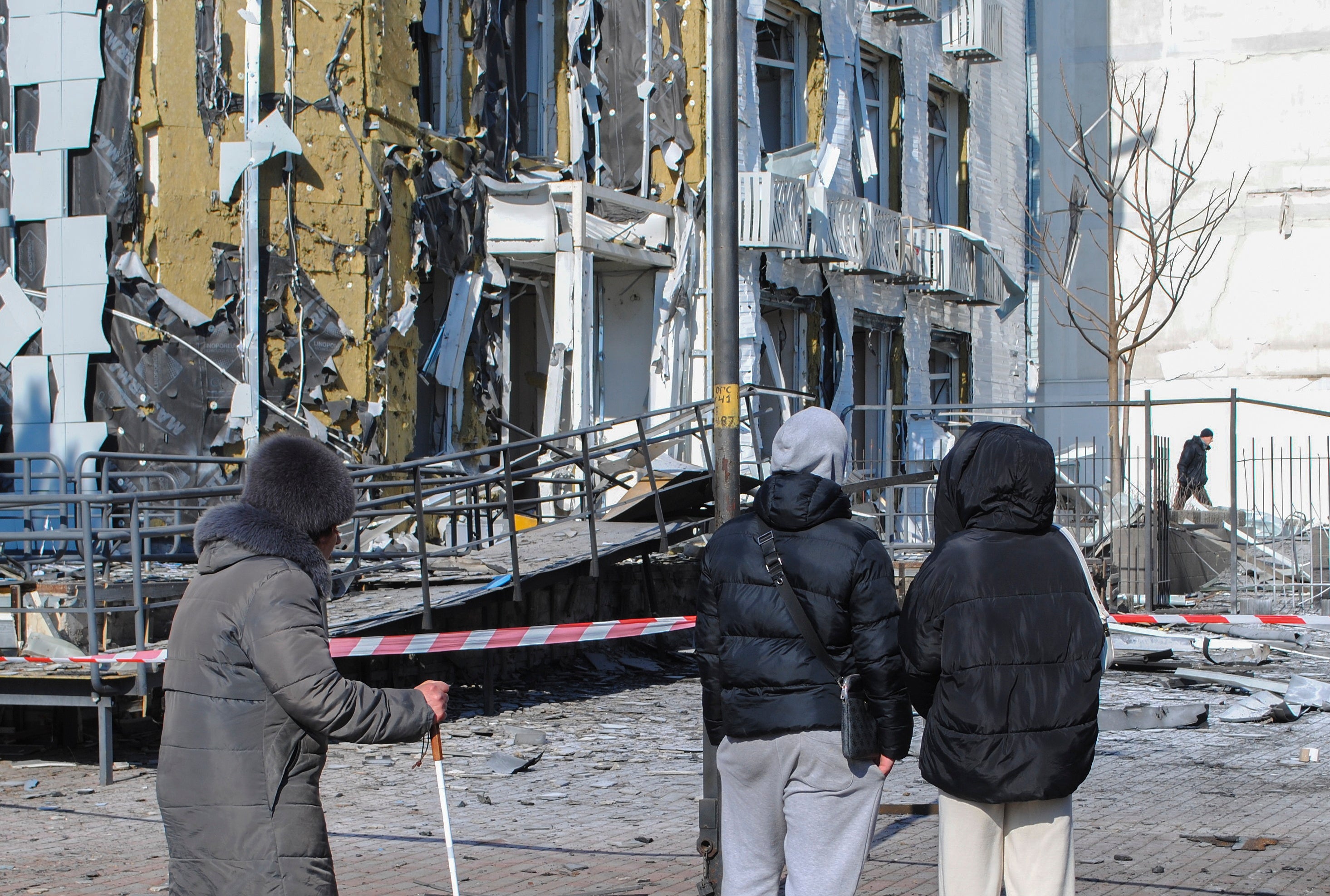 epa119070Local people stand near a damaged chilldren's clinic after drone strikes hit Odesa, southwestern Ukraine, 19 February 2025, amid the Russian invasion