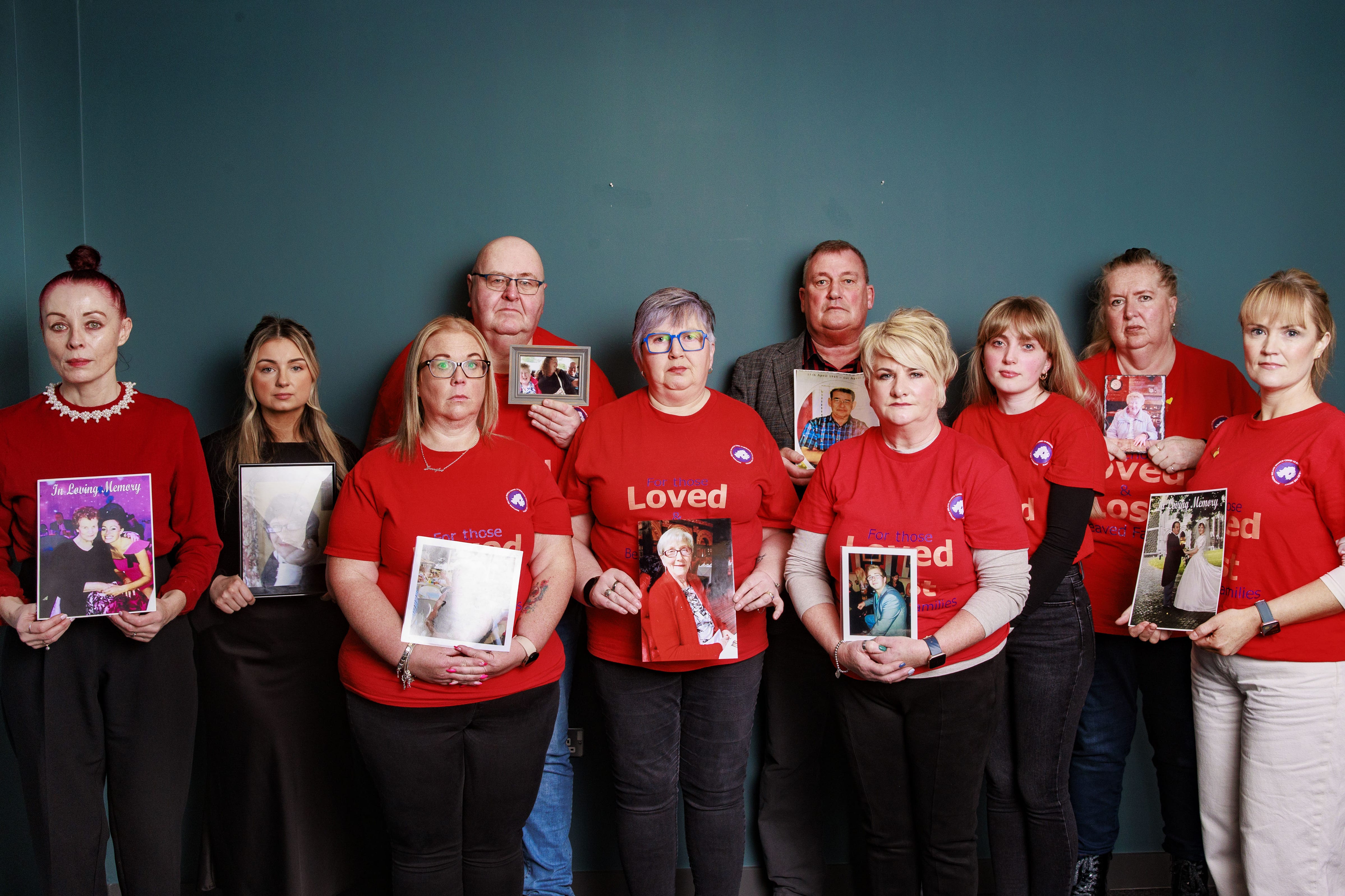 (Left to right) Martina Ferguson, Chanel Gillen, Jennifer Currie, Michael Lusty, Brenda Doherty, Trevor Patterson, Briege McAvoy, Lauren Mallon, Fiona Clarke and Catroina Myles with pictures of loved ones lost during the pandemic at PA Duffy & Co Solicitors offices in Belfast (Liam McBurney/PA)
