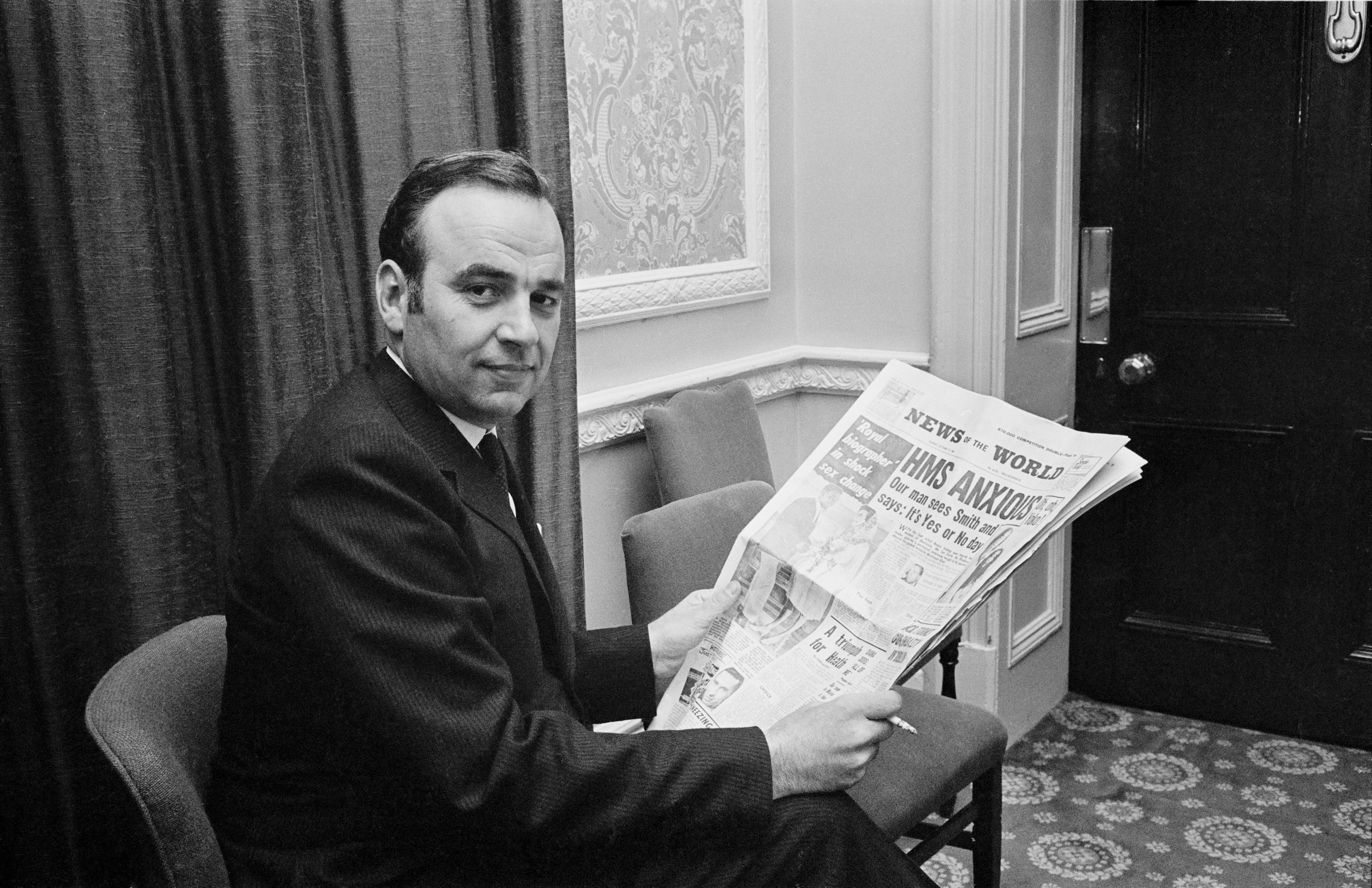 Rupert Murdoch holding a copy of the News of the World in 1968