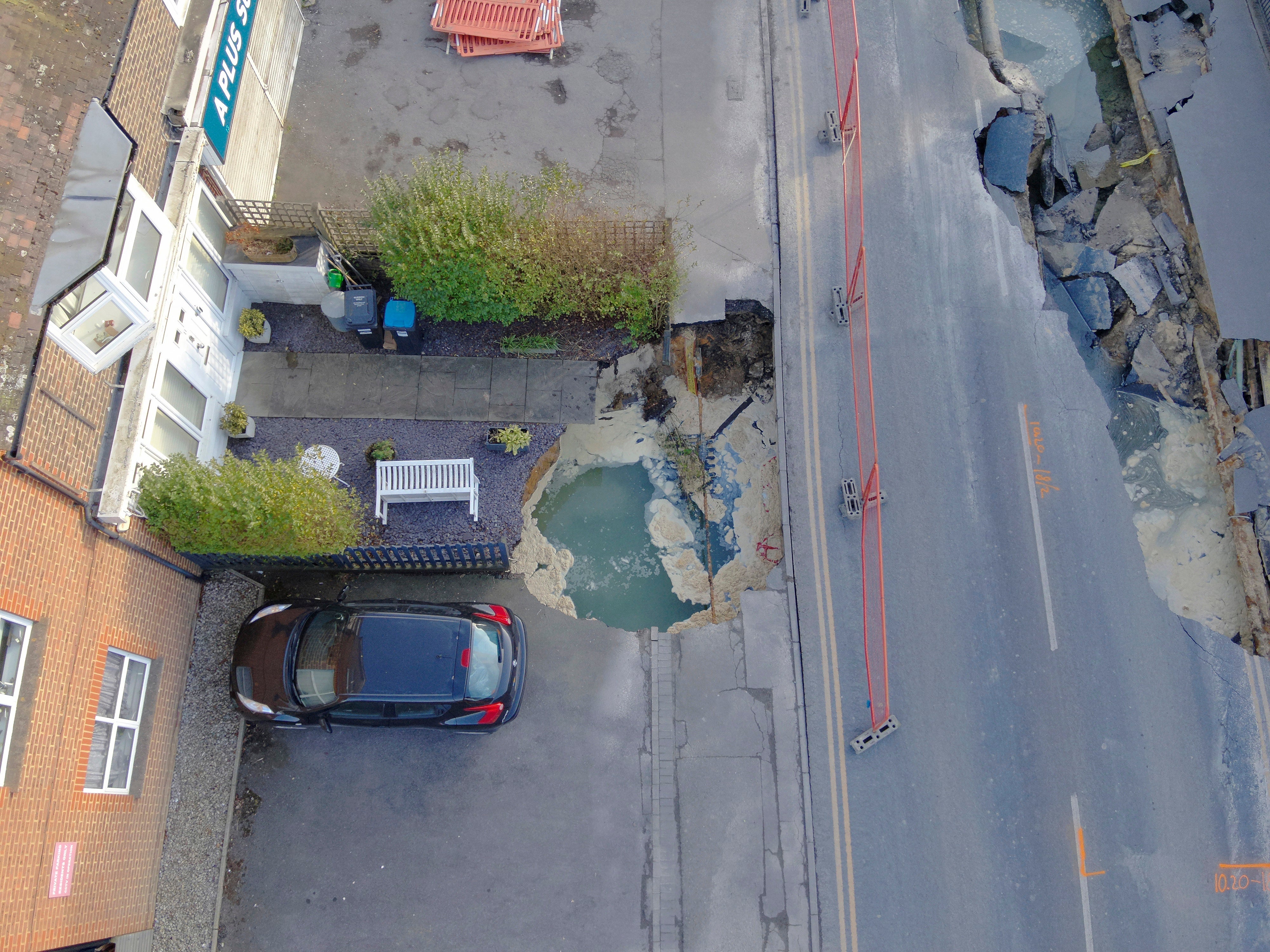 A car teeters on the edge of a second crater in Godstone