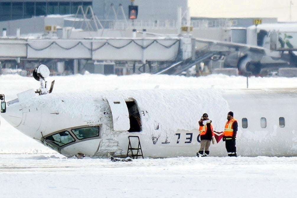 The Delta Airlines plane lies upside down at Toronto Pearson Airport
