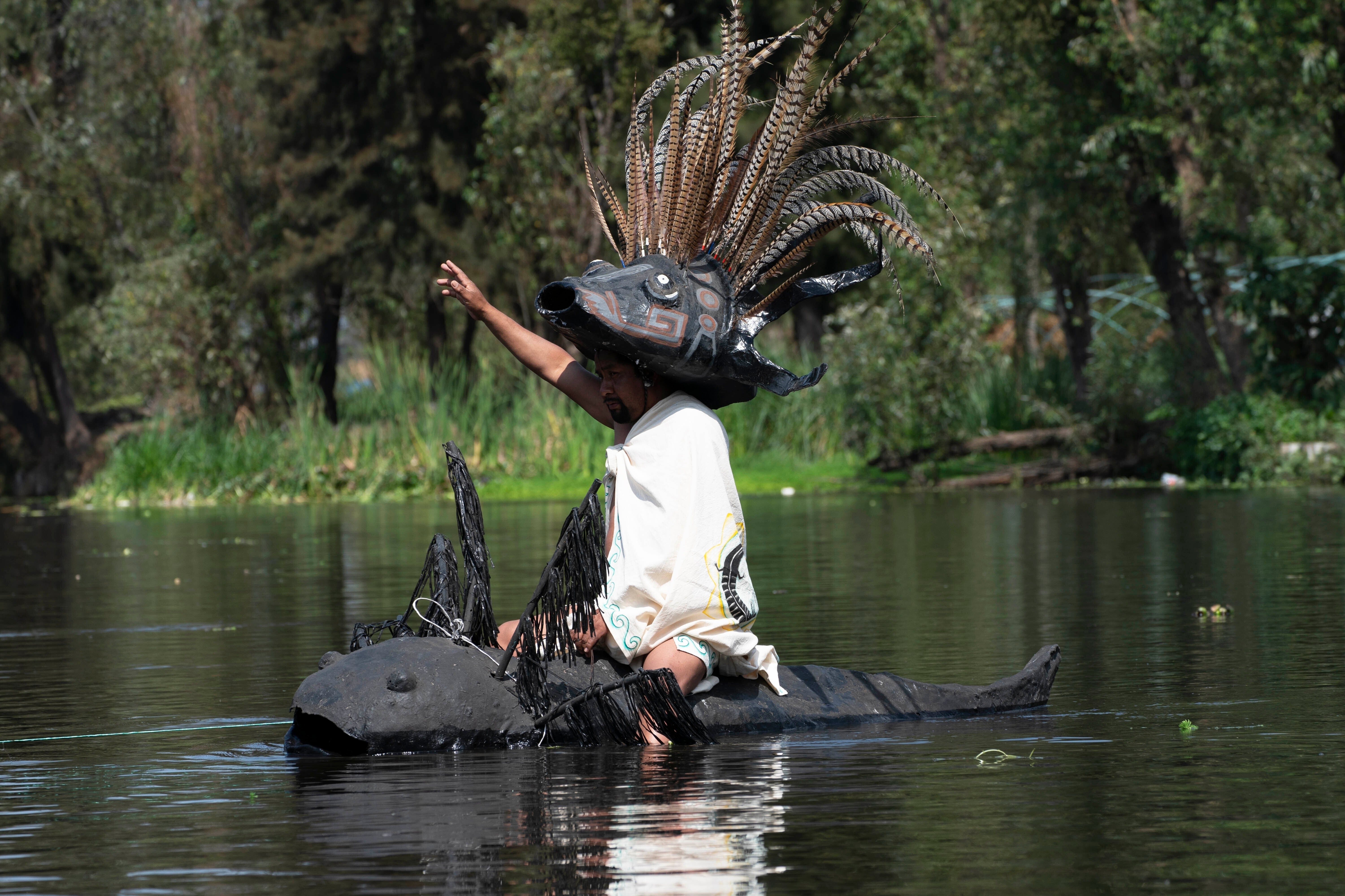 Manuel Rodriguez sits atop a canoe shaped like an axolotl during its symbolic release in the canals of Xochimilco, a borough of Mexico City