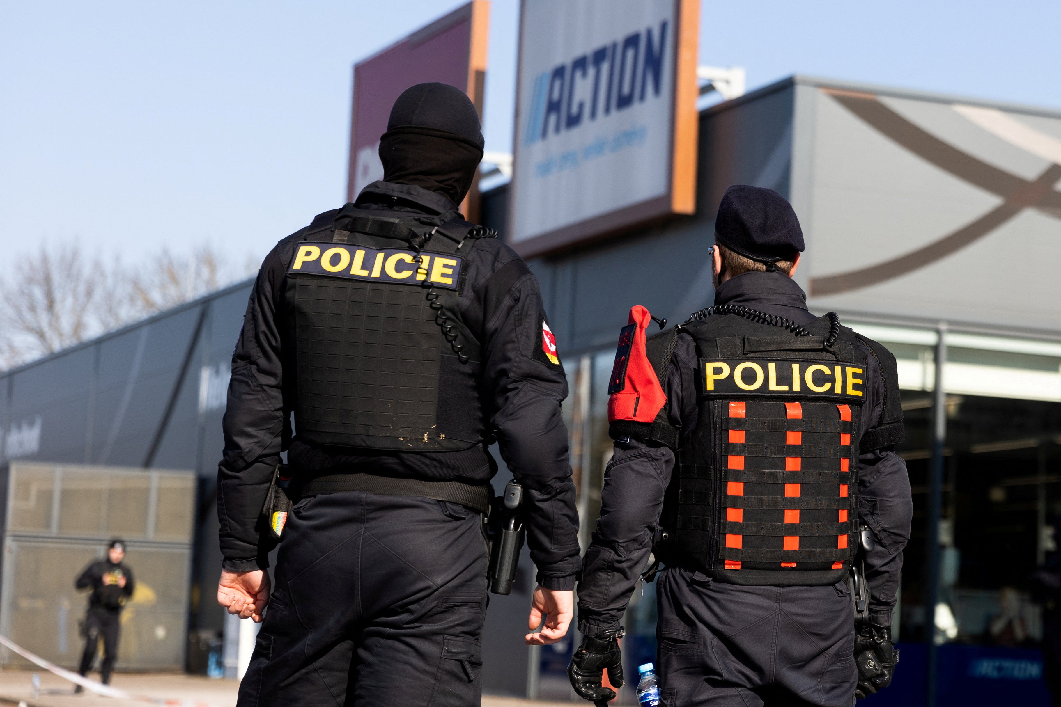 Police officers stand guard in a shopping area at the site where two women have died in a knife attack in Hradec Kralove
