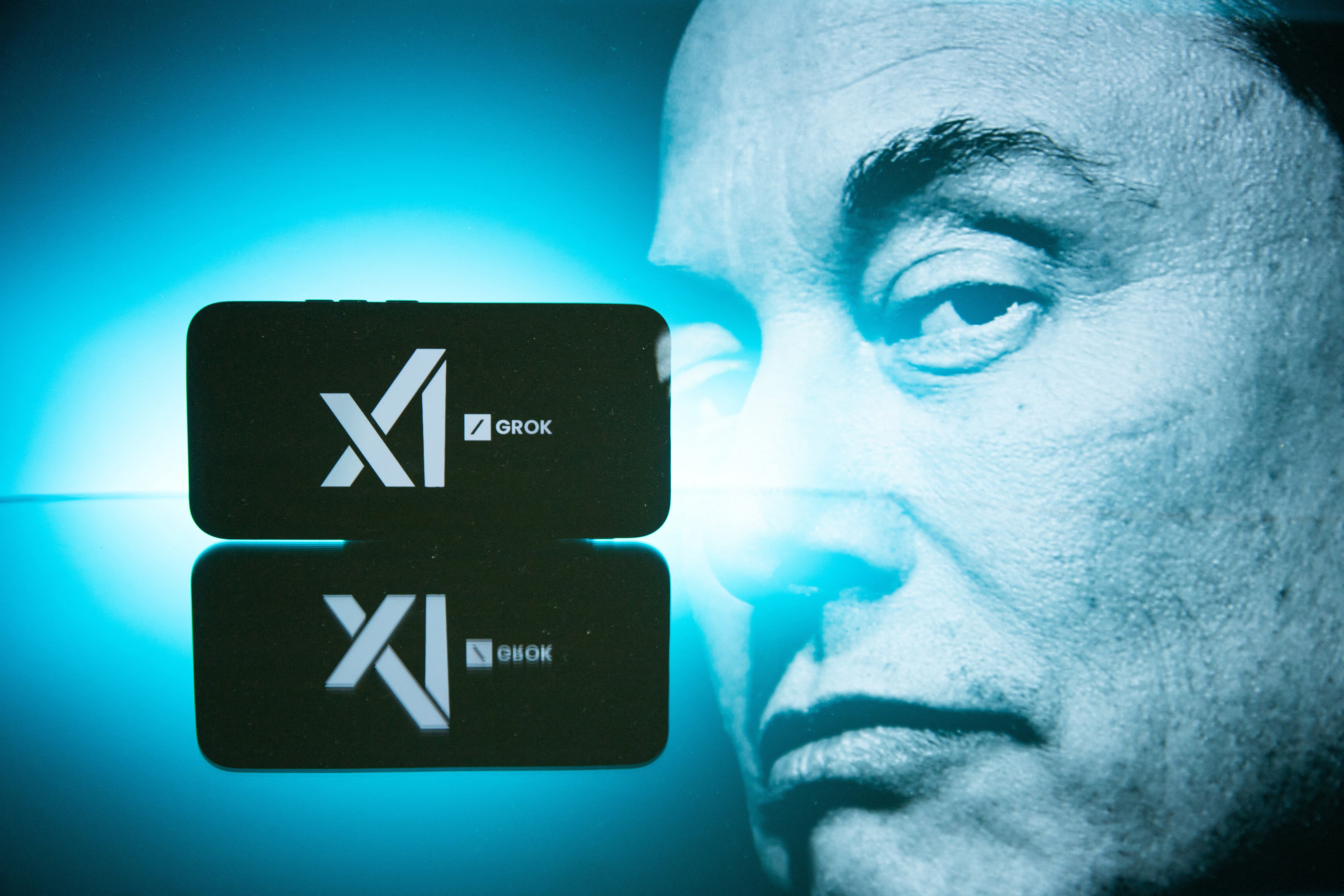 Double-exposure photography shows Elon Musk next to an emblem for Grok and his artificial intelligence company