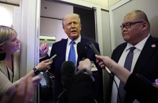 U.S. President Donald Trump speaks to reporters aboard Air Force One on his return to Washington, D.C., on February 19 2025