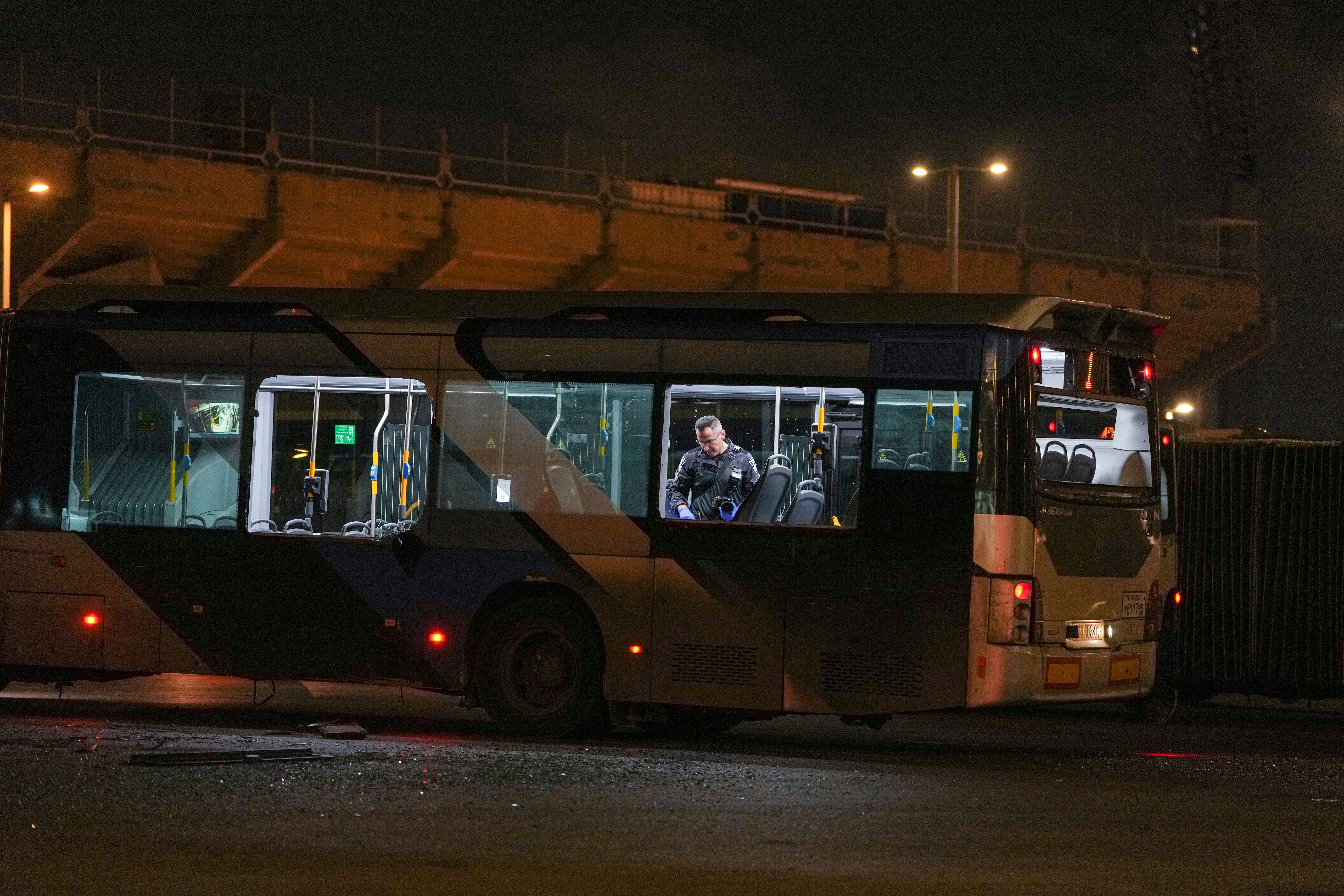 Israeli police search a bus in Bat Yam after three vehicles exploded on Thursday