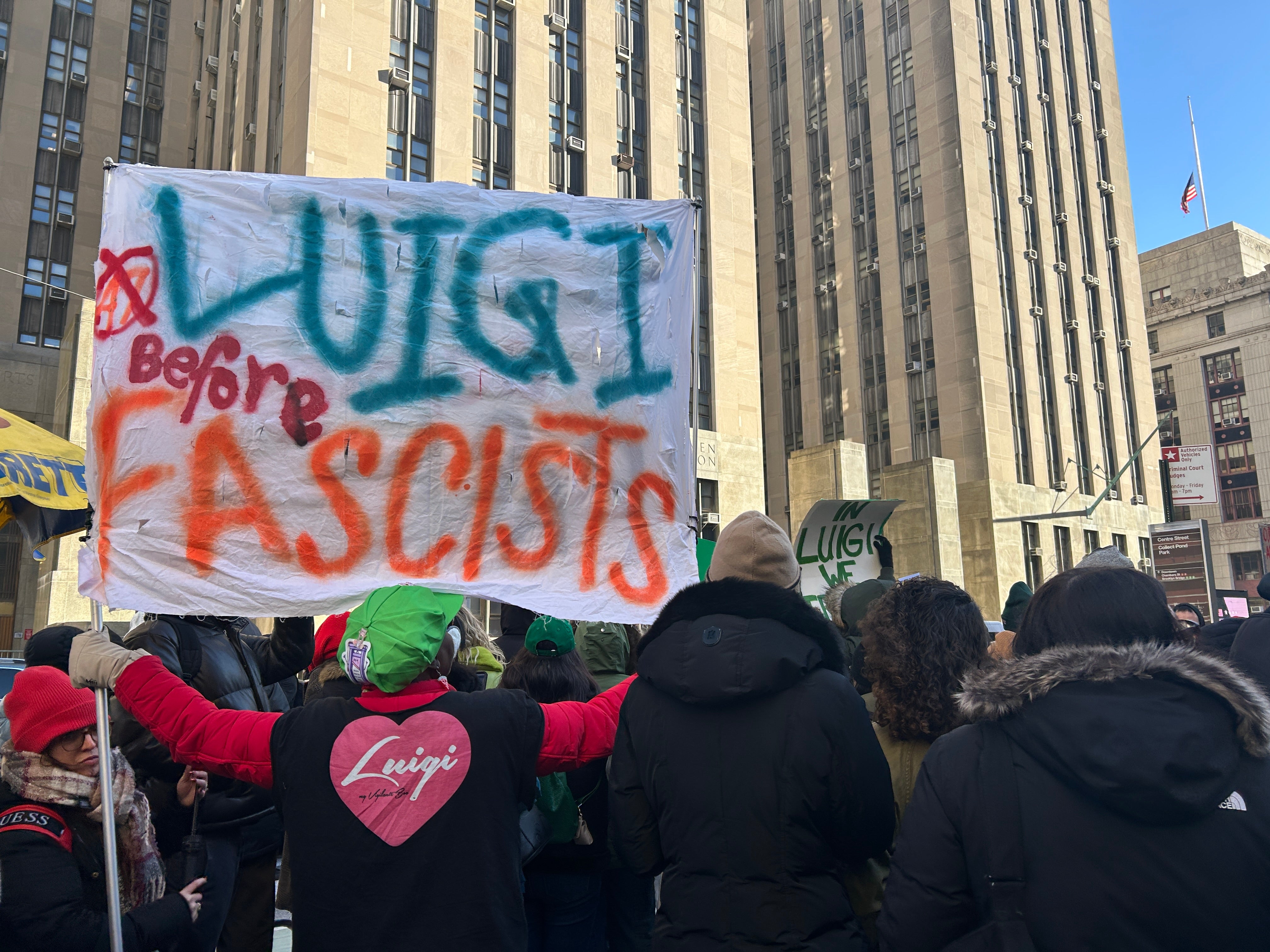 'Luigi before fascists,' reads a sign held up by a protester wearing a green hat and a jacket with a heart on the back with the name Luigi inside