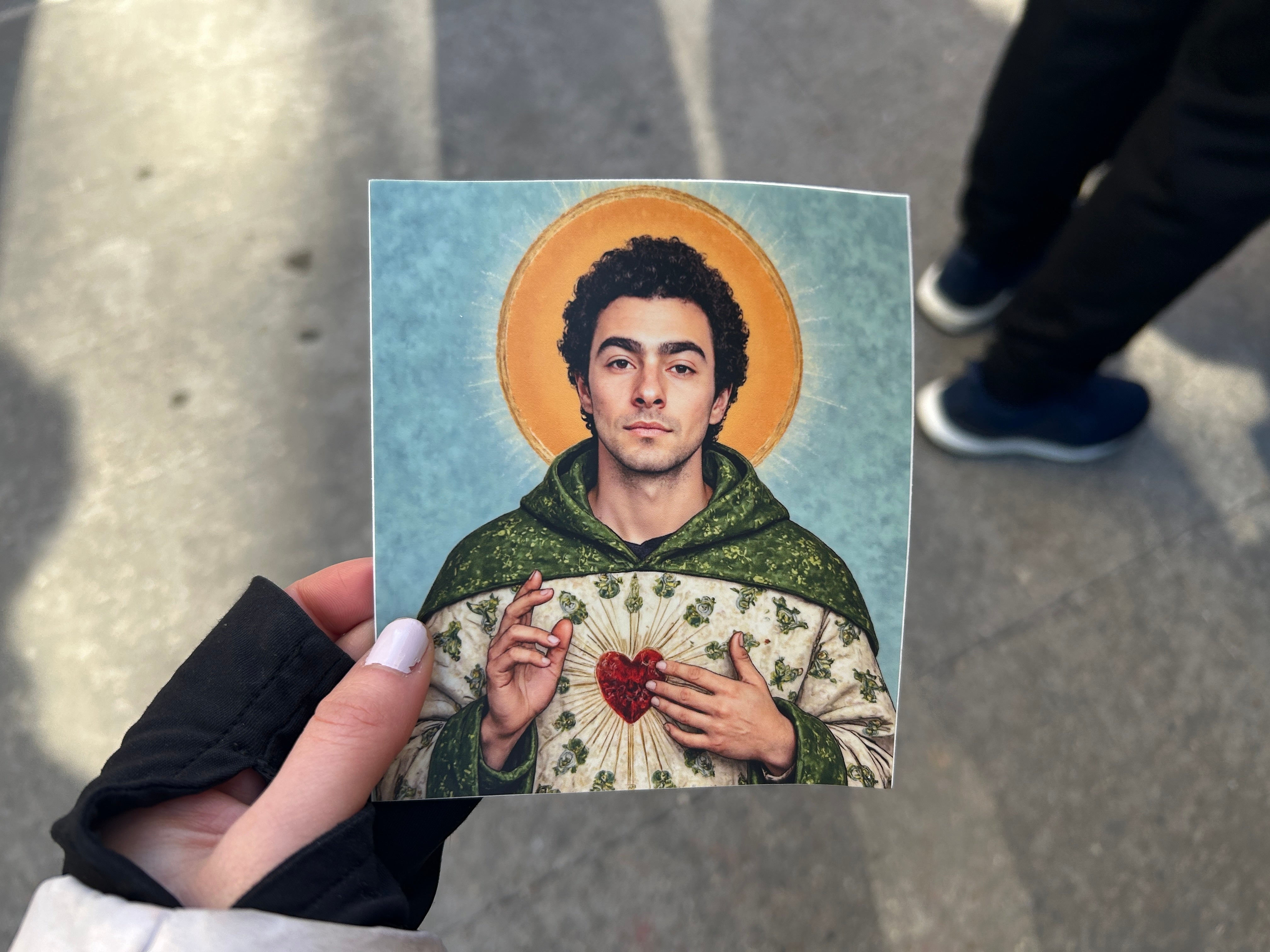 Demonstrators hand out stickers featuring Mangione depicted as Jesus Christ