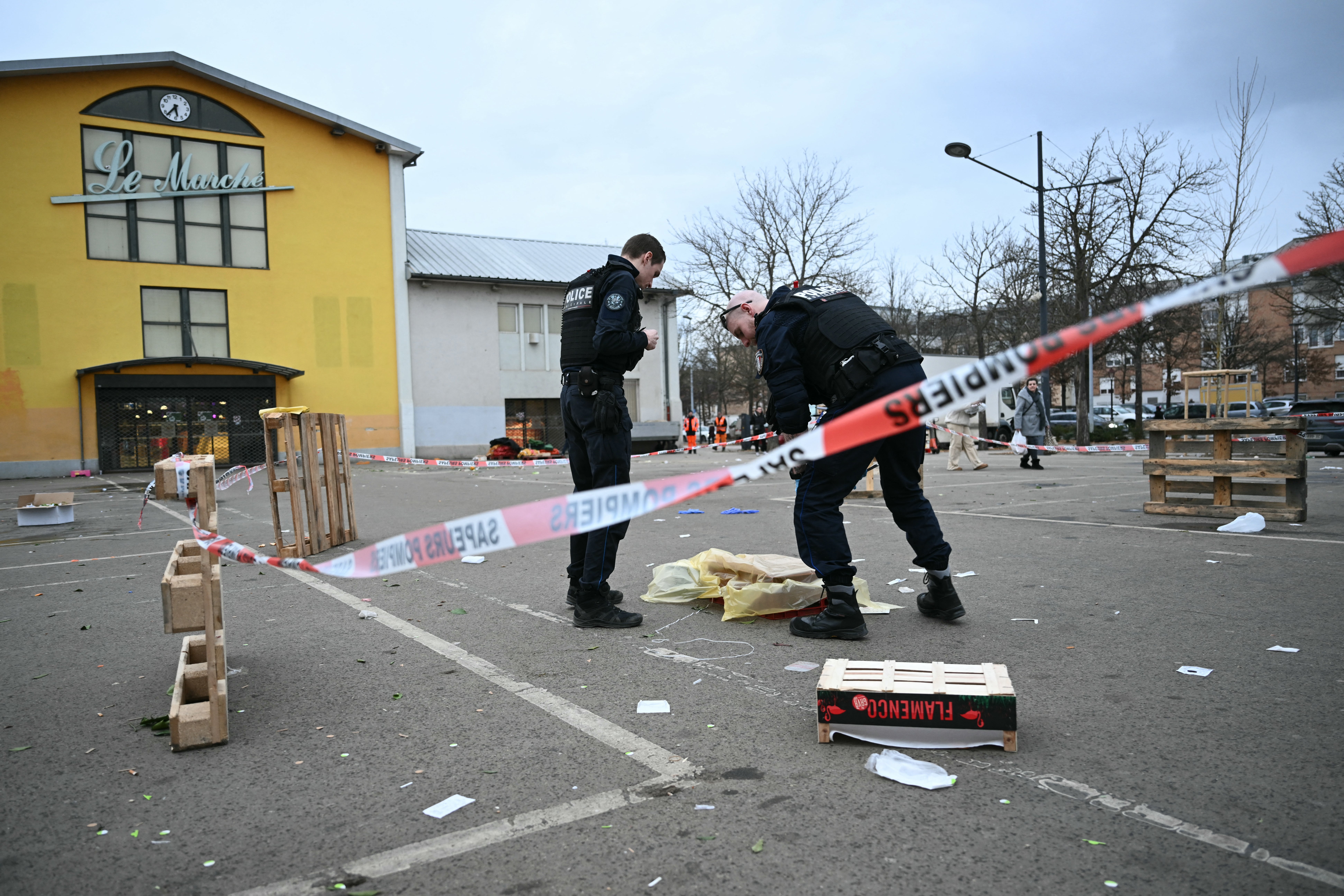 Police officers work to collect evidence at the site of the attack in Mulhouse on Saturday