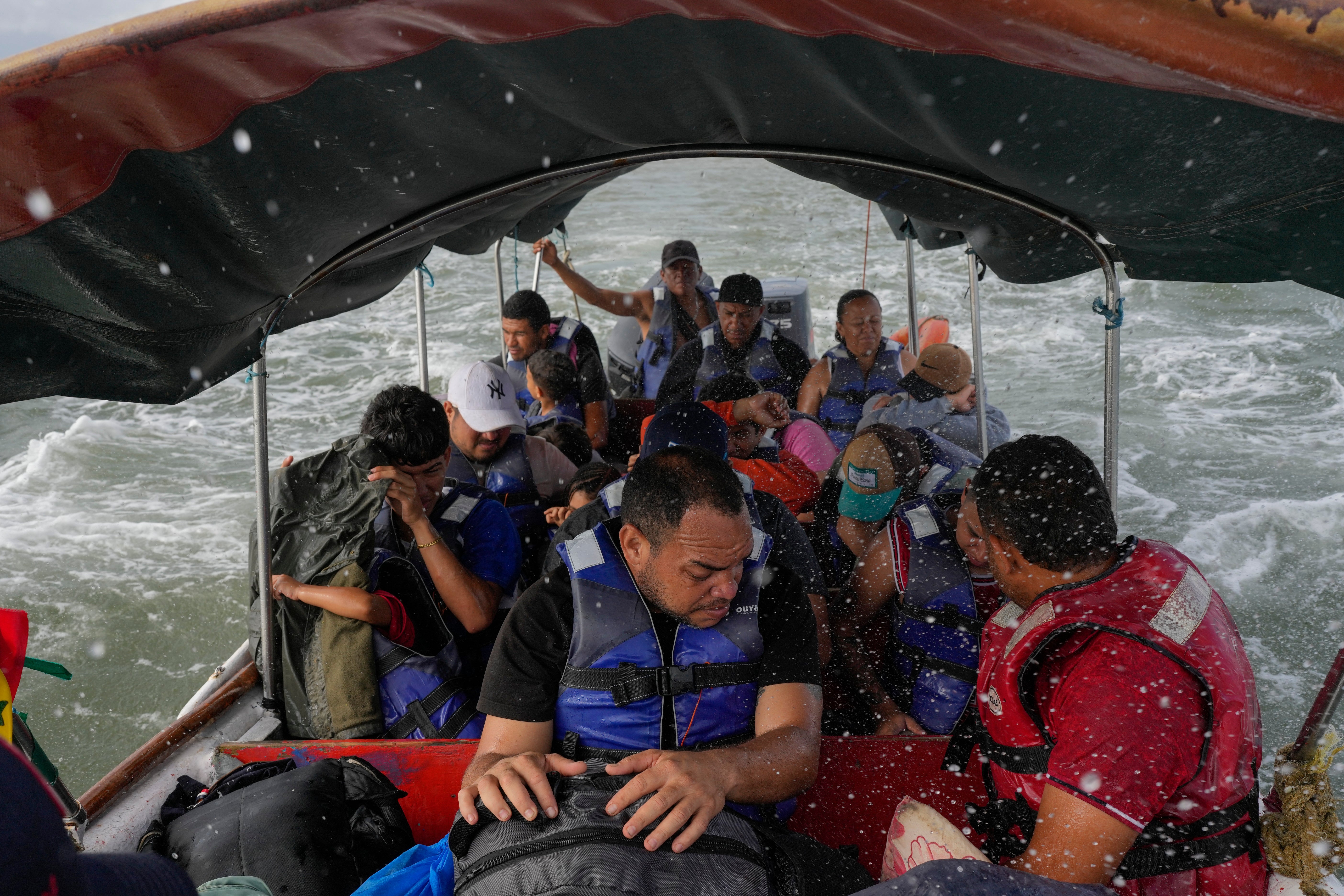 Luis Sanchez, center, on a boat with other Venezuelan migrants as it departs Panama