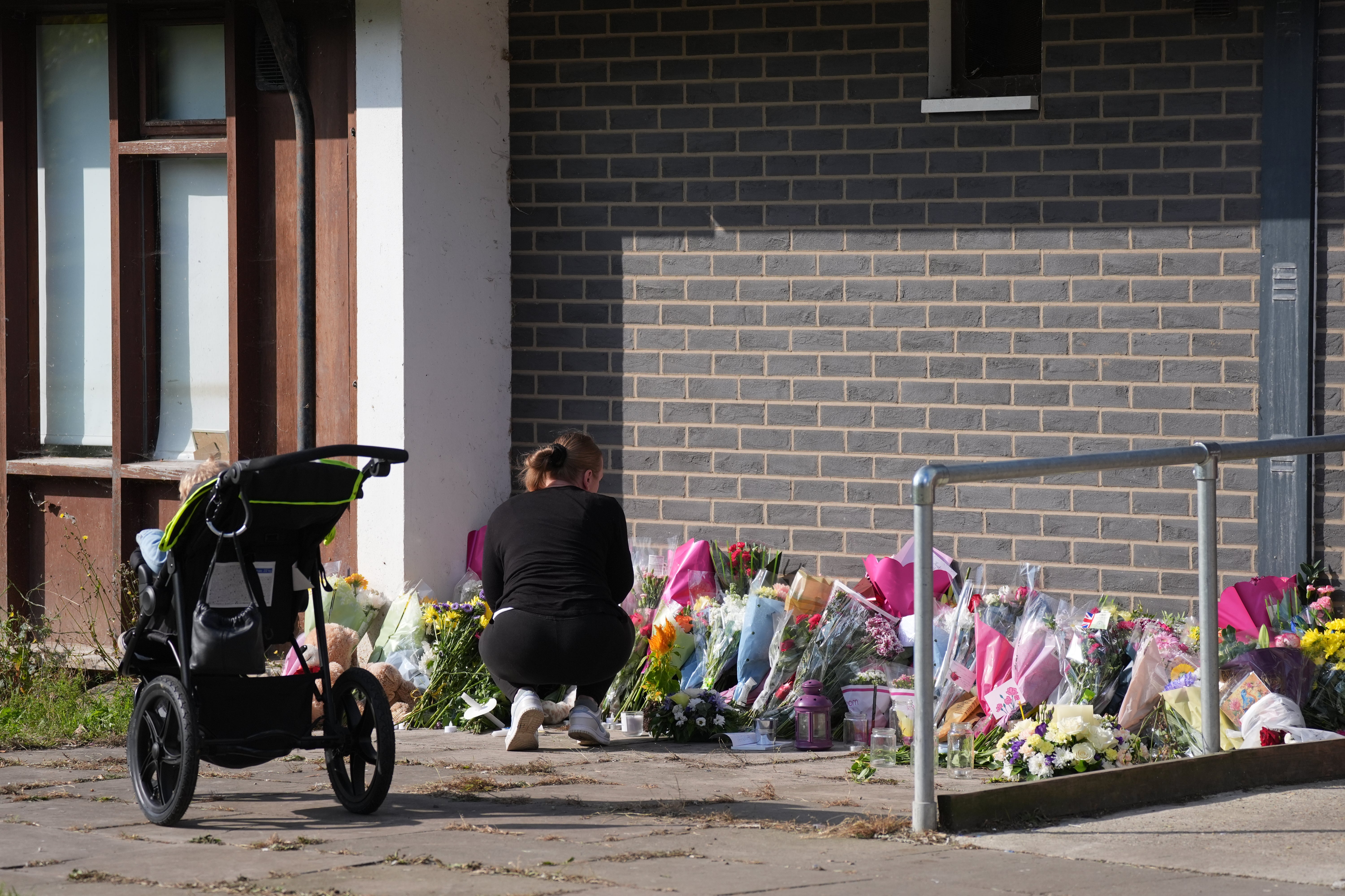 A woman lays flowers near the scene of the killings