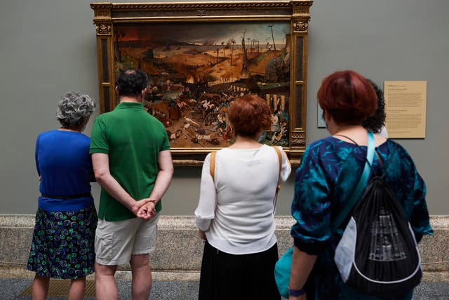 <p>Visitors look at the Pieter Bruegel painting 'The Triumph of Death' </p>