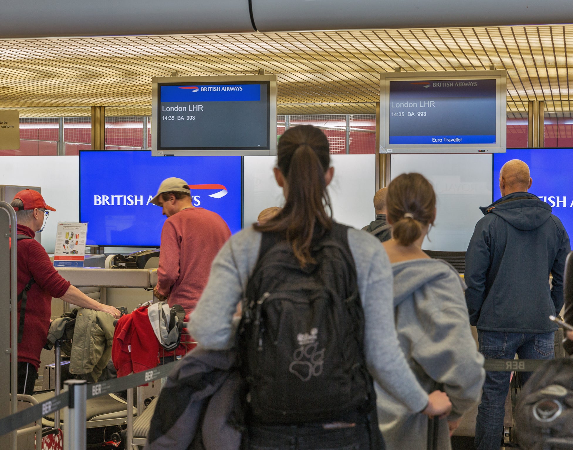 Passengers check in with luggage for flight to London at the British Airways desk in Tegel Airport, the main international airport of the capital of Germany