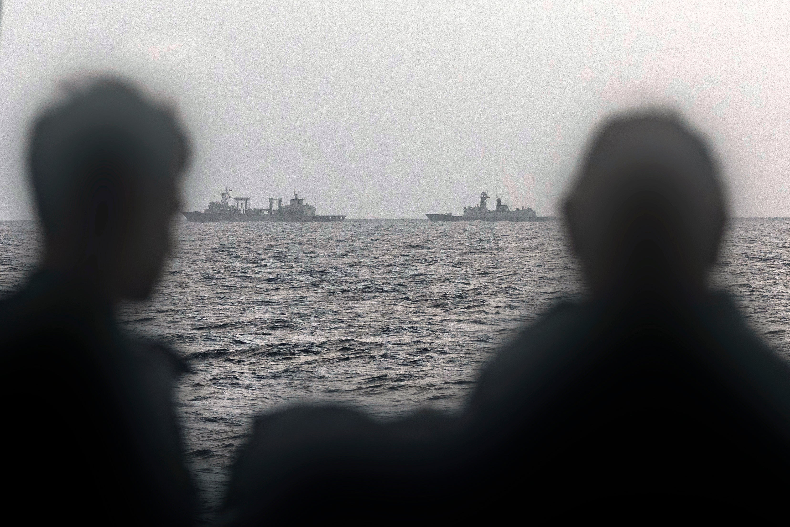 Sailors onboard the Royal Australian Navy ship HMAS Arunta looking at the People's Liberation Army-Navy (PLA-N) Fuchi-class replenishment vessel
