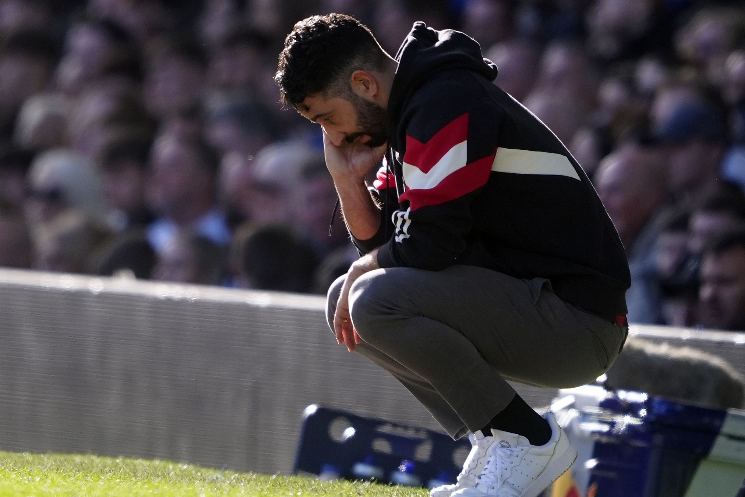 Ruben Amorim crouches down on the touchline (Peter Byrne/PA)