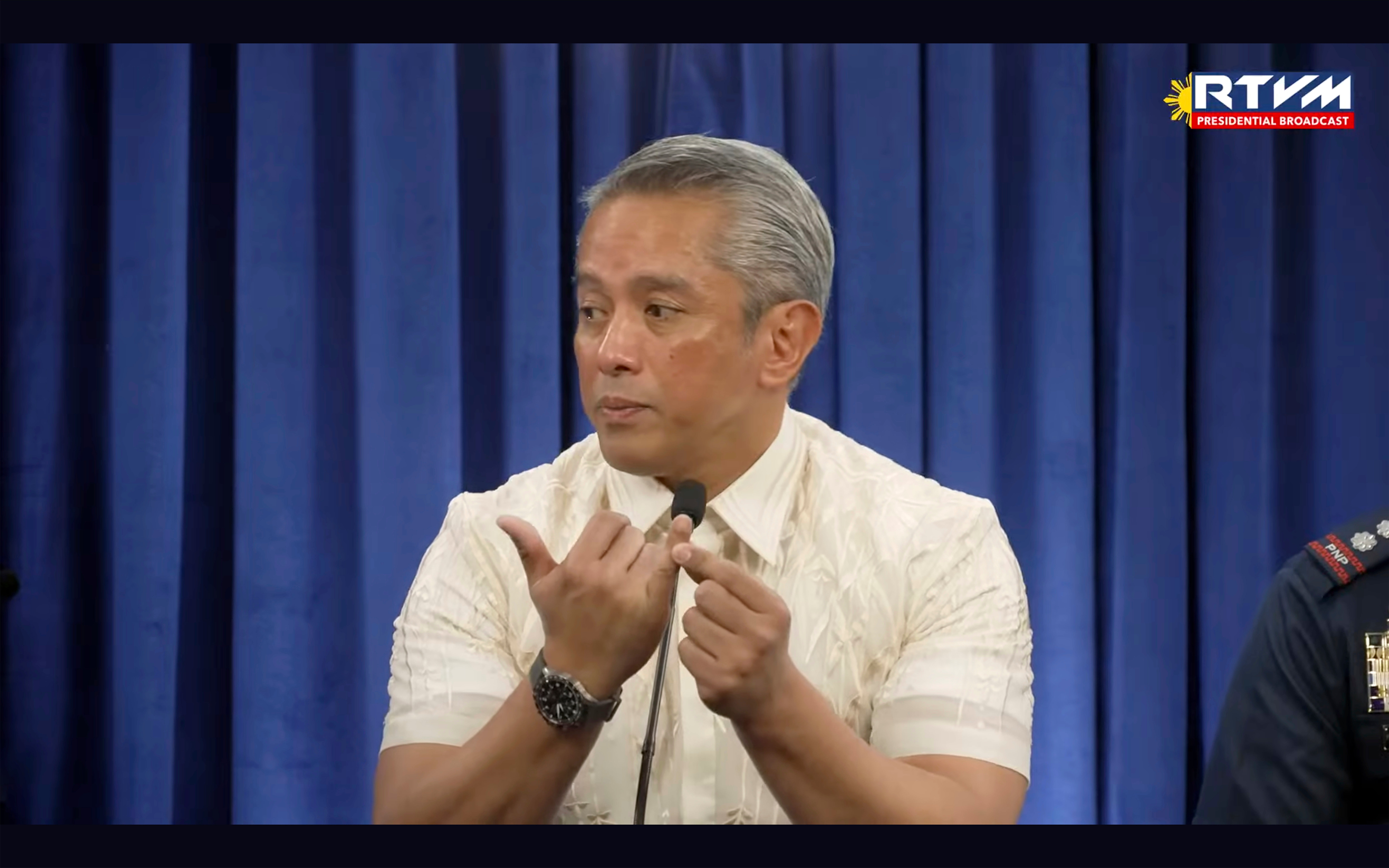 In this image made from video provided by RTVM, Filipino interior secretary Jonvic Remulla points to a finger when referring to which finger of the Chinese student was cut off after being kidnapped by a Chinese-led gang, at a press briefing in Manila, Wednesday, 26 February 2025