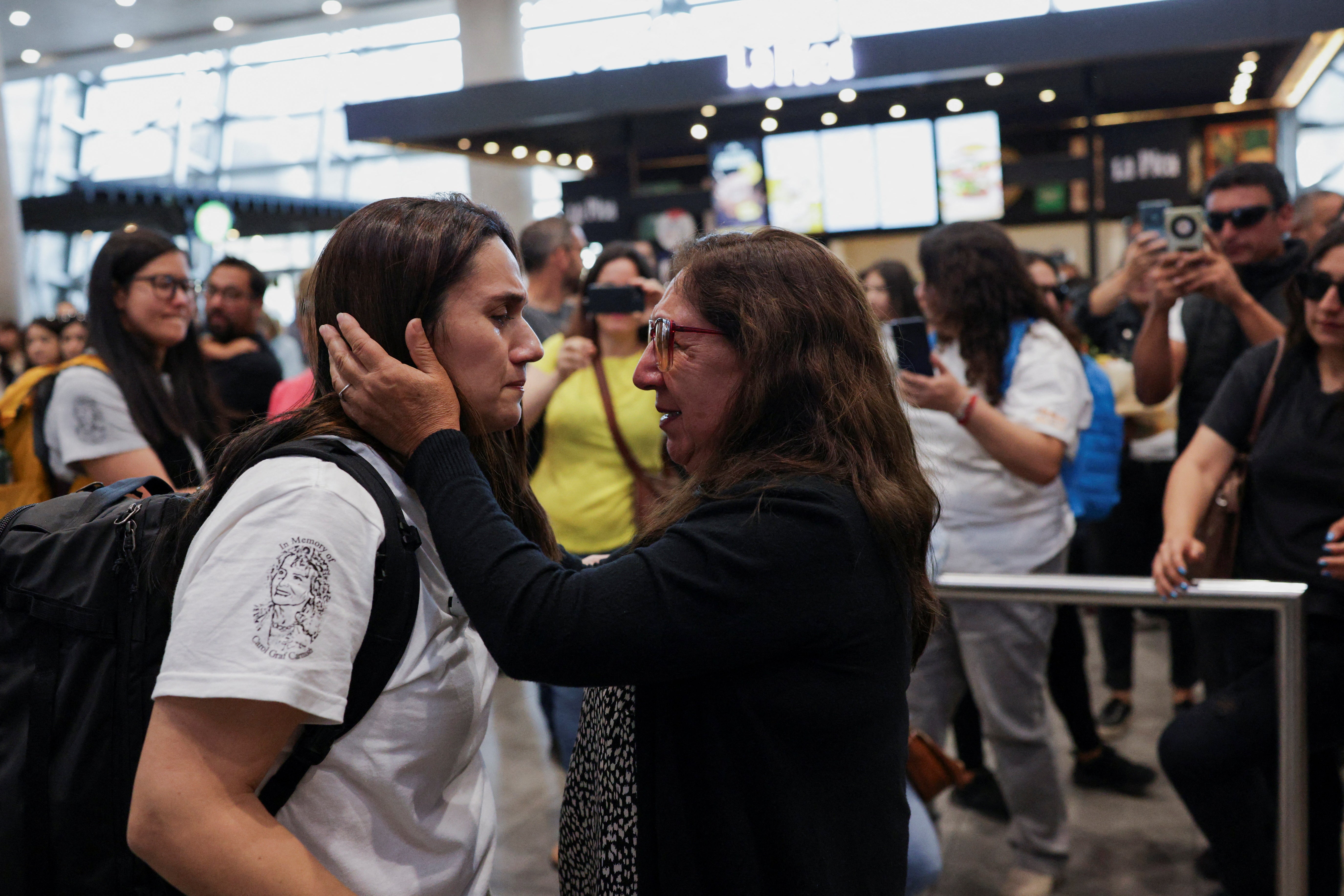 Edita Bizama touches the face of her daughter Adamary Garcia at the airport in Santiago, Chile