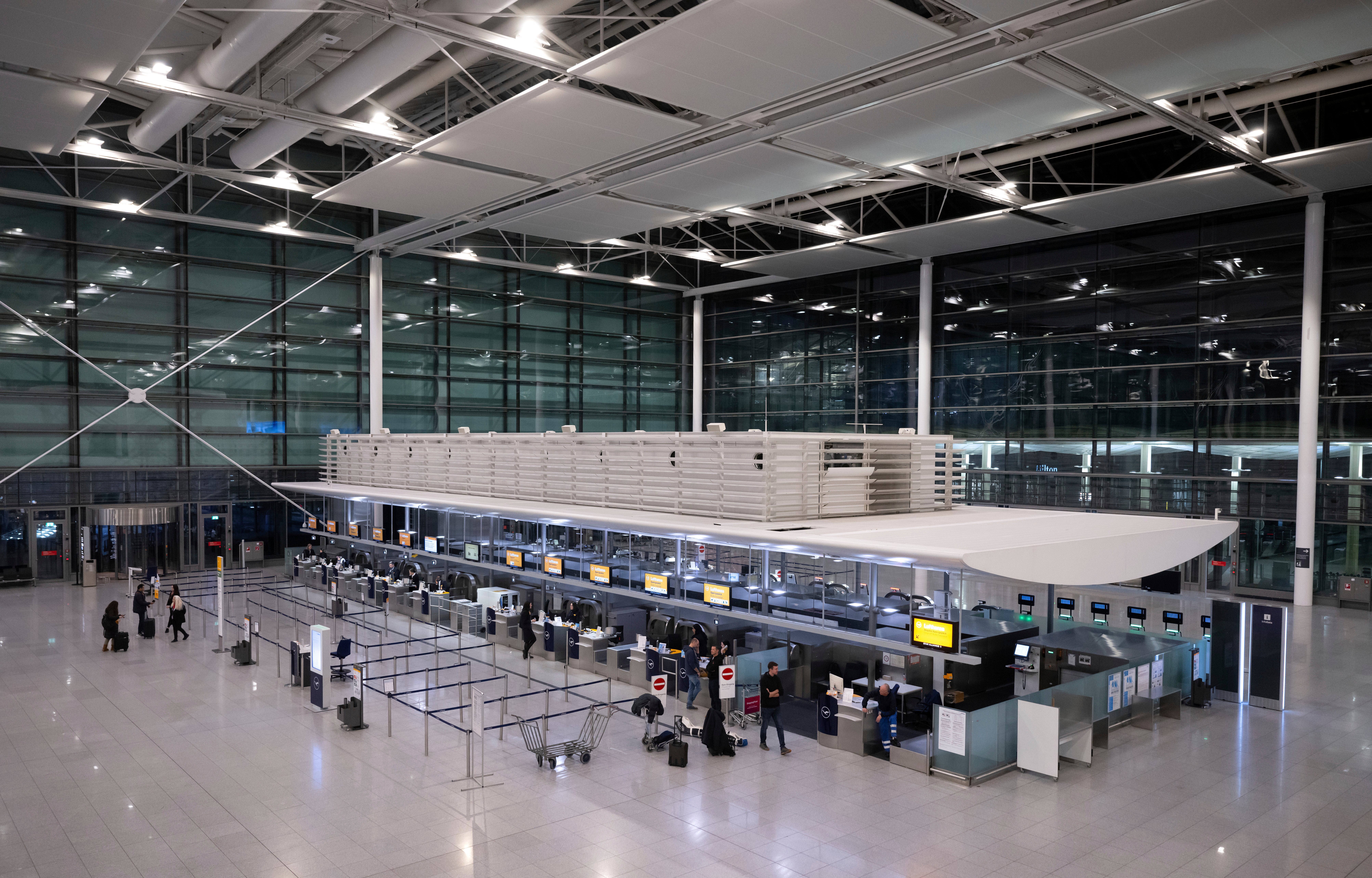 Passengers arrive with their luggage at a Lufthansa check-in counter at the Munich Airport in Munich, Germany, Thursday, 27 February