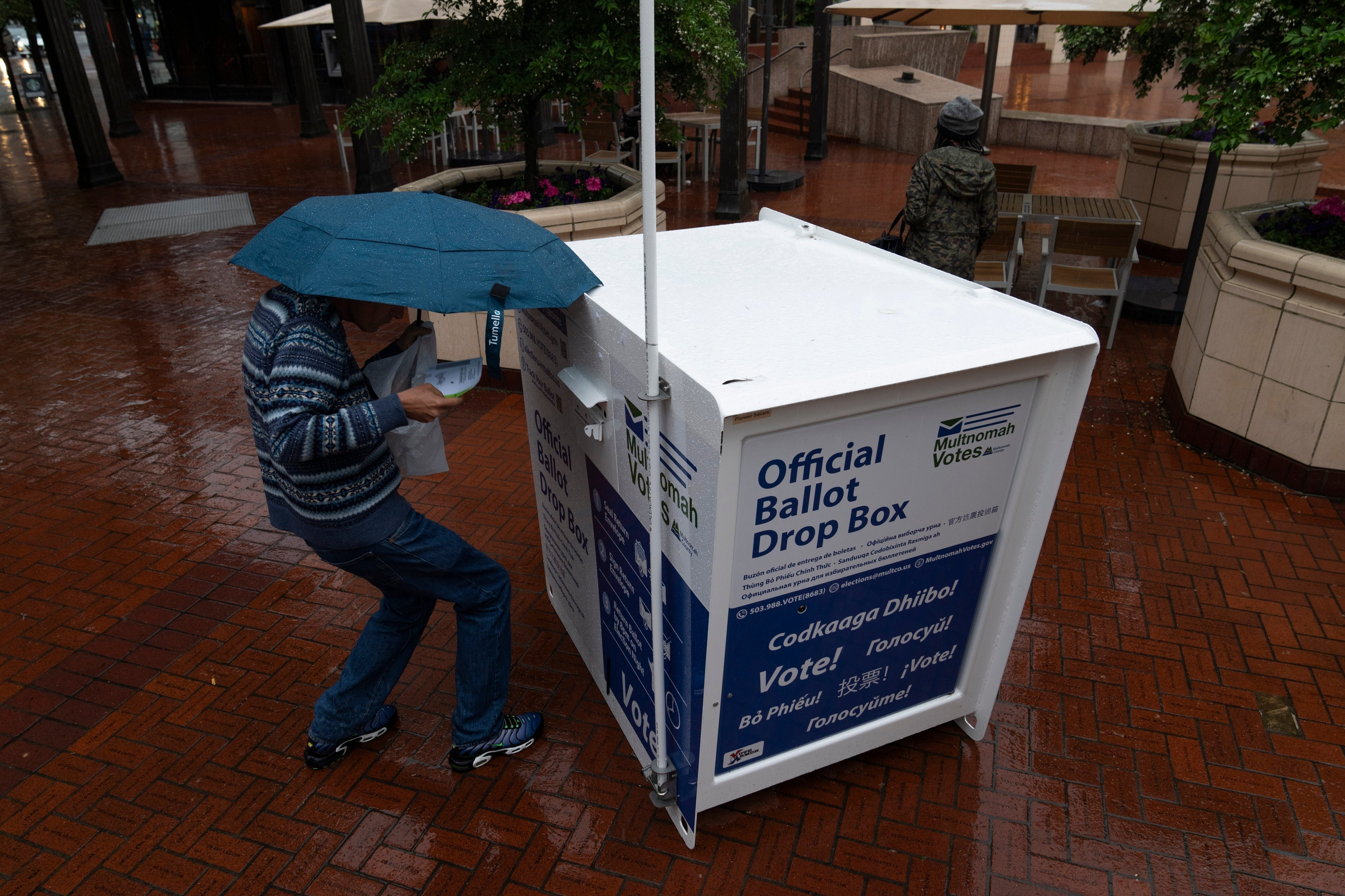 A person drops off their mail-in ballot in Oregon in 2024