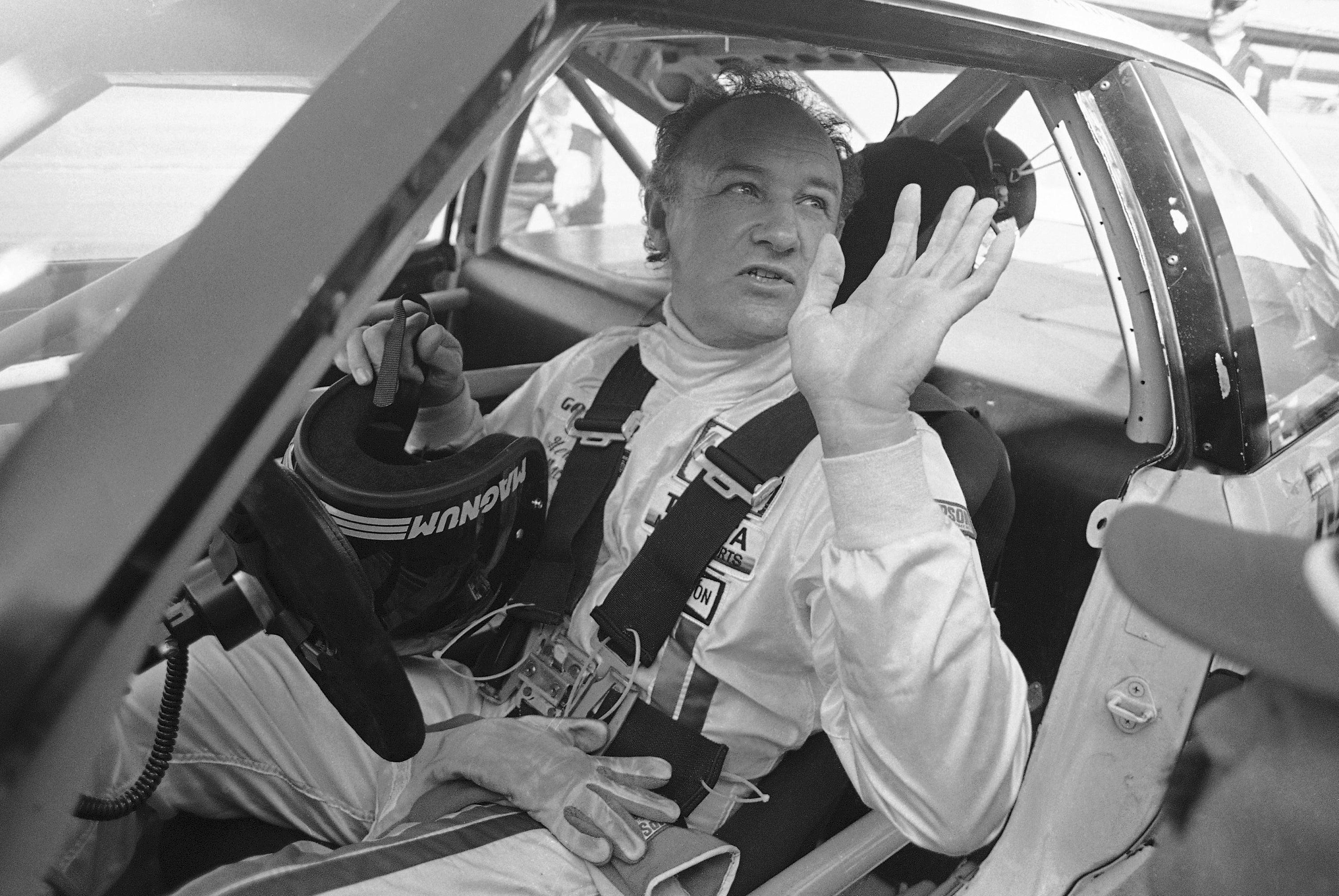 Actor Gene Hackman waves as he starts out for a practice run in his Toyota Celica in 1983 (AP/Bob Self)