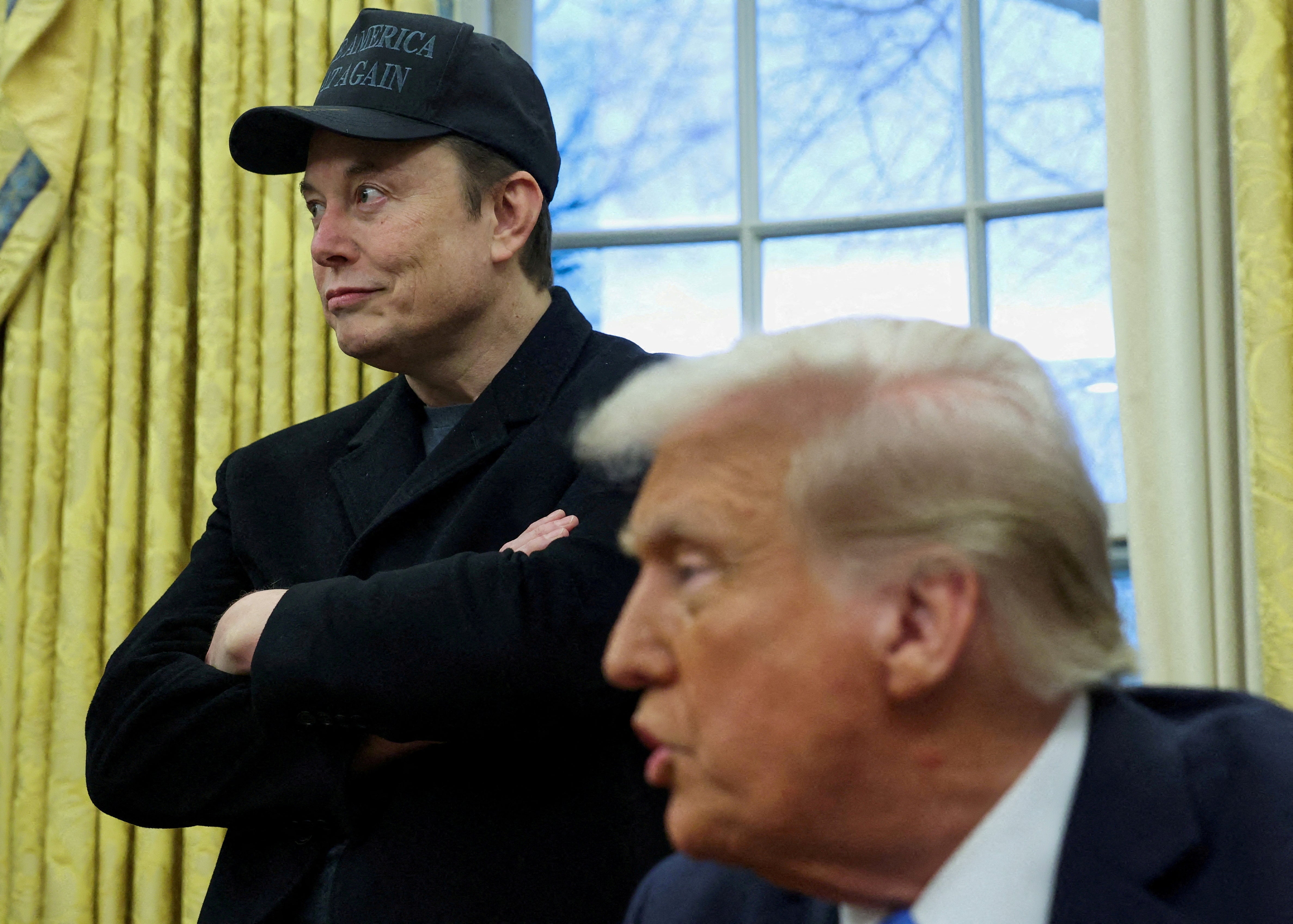 Elon Musk listens to US President Donald Trump speak in the Oval Office