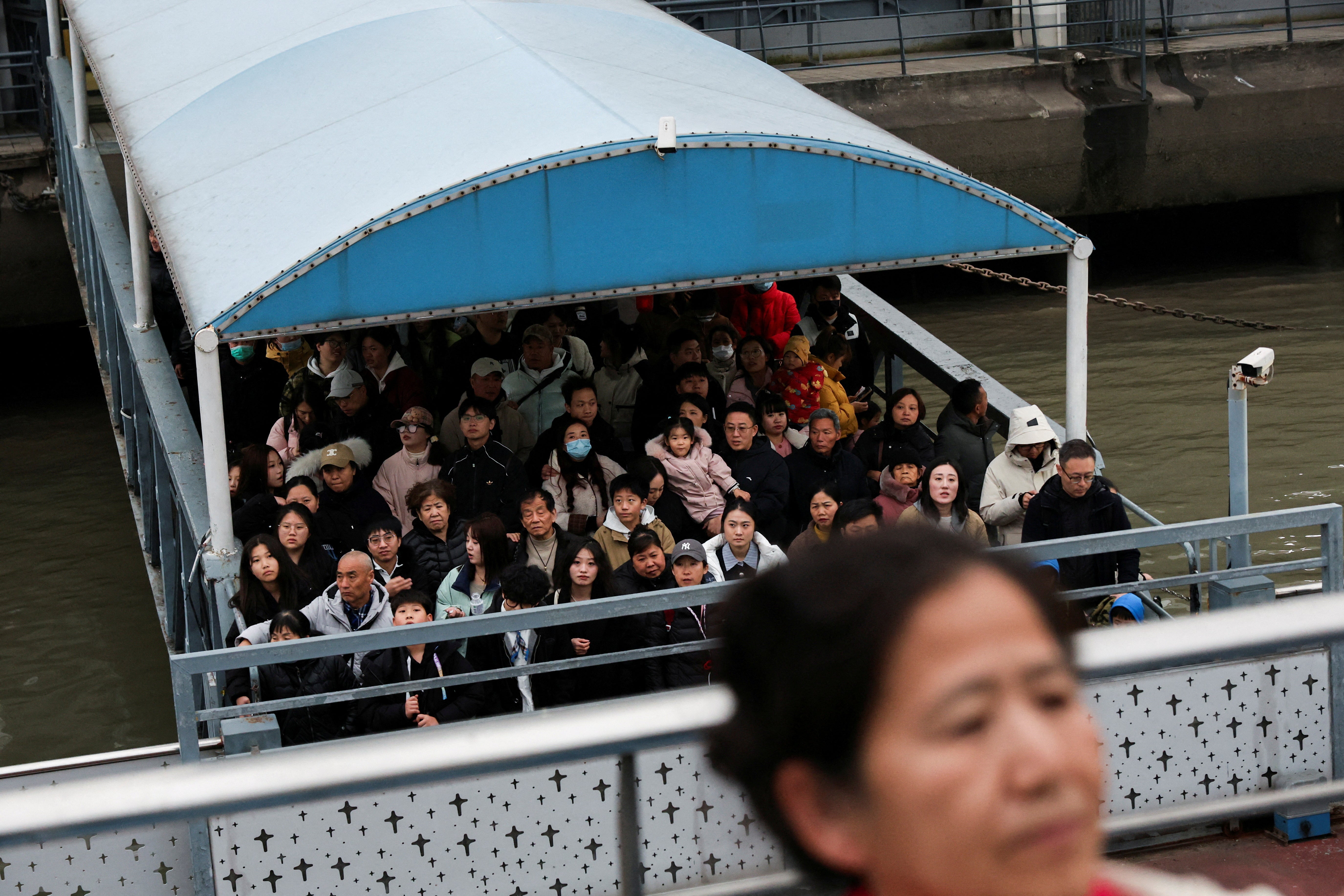 File image: People stand as they wait to board a ferry to cross the Huangpu River in Shanghai