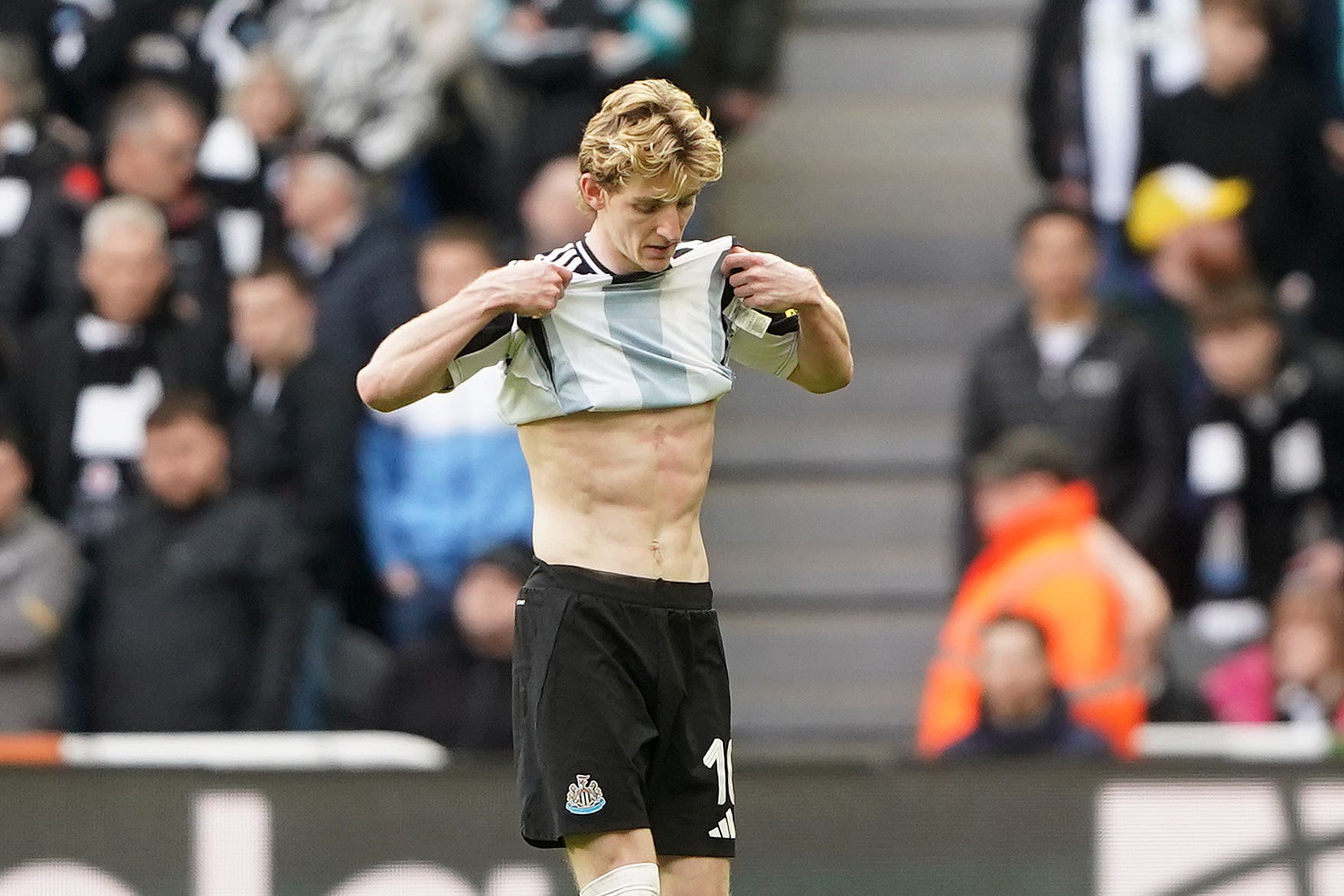 Anthony Gordon leaves the pitch after being shown a red card