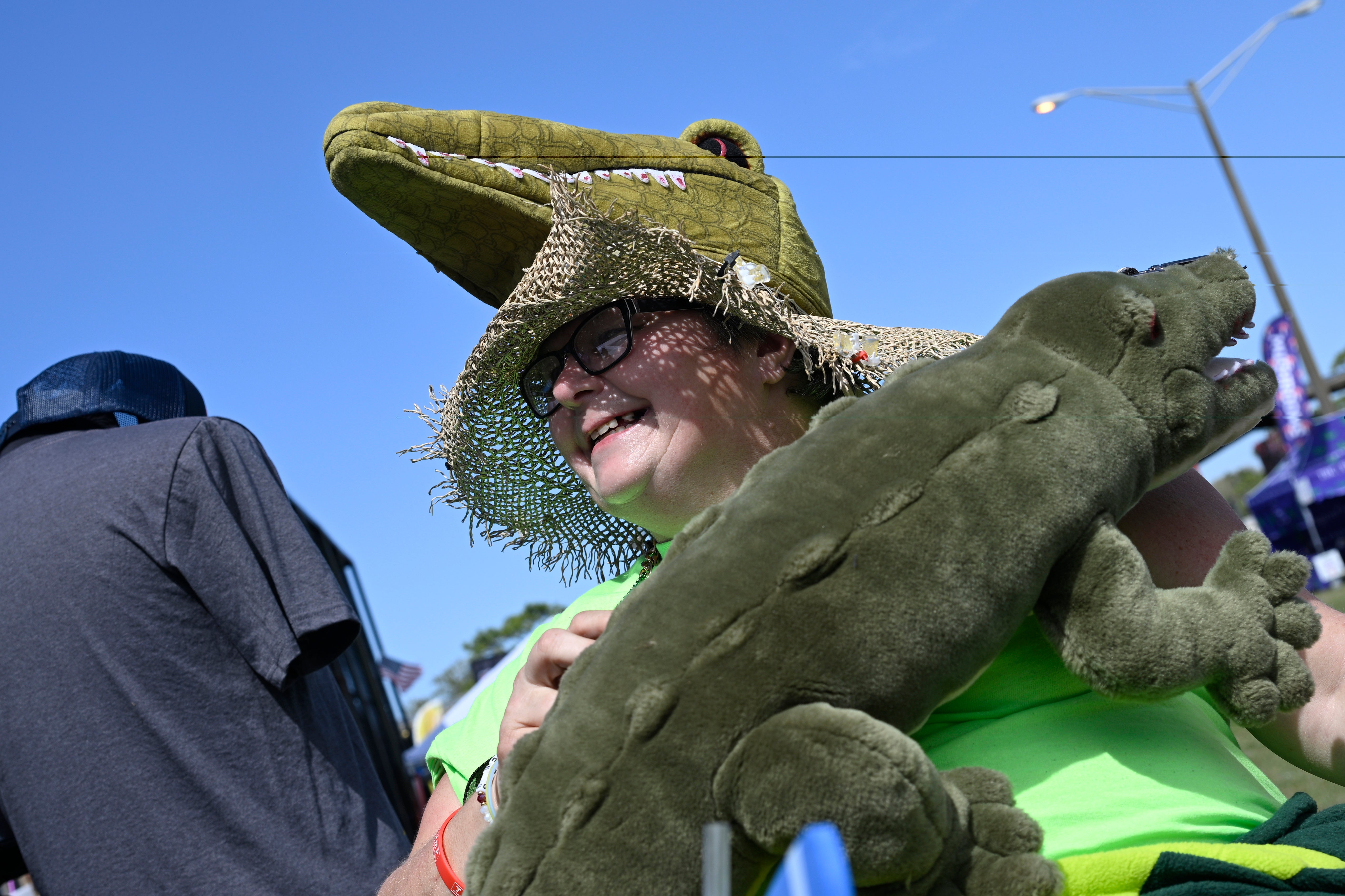Annie Polen, of Tampa, wears a homemade alligator hat and a stuffed alligator purse while attending the Florida Man Games