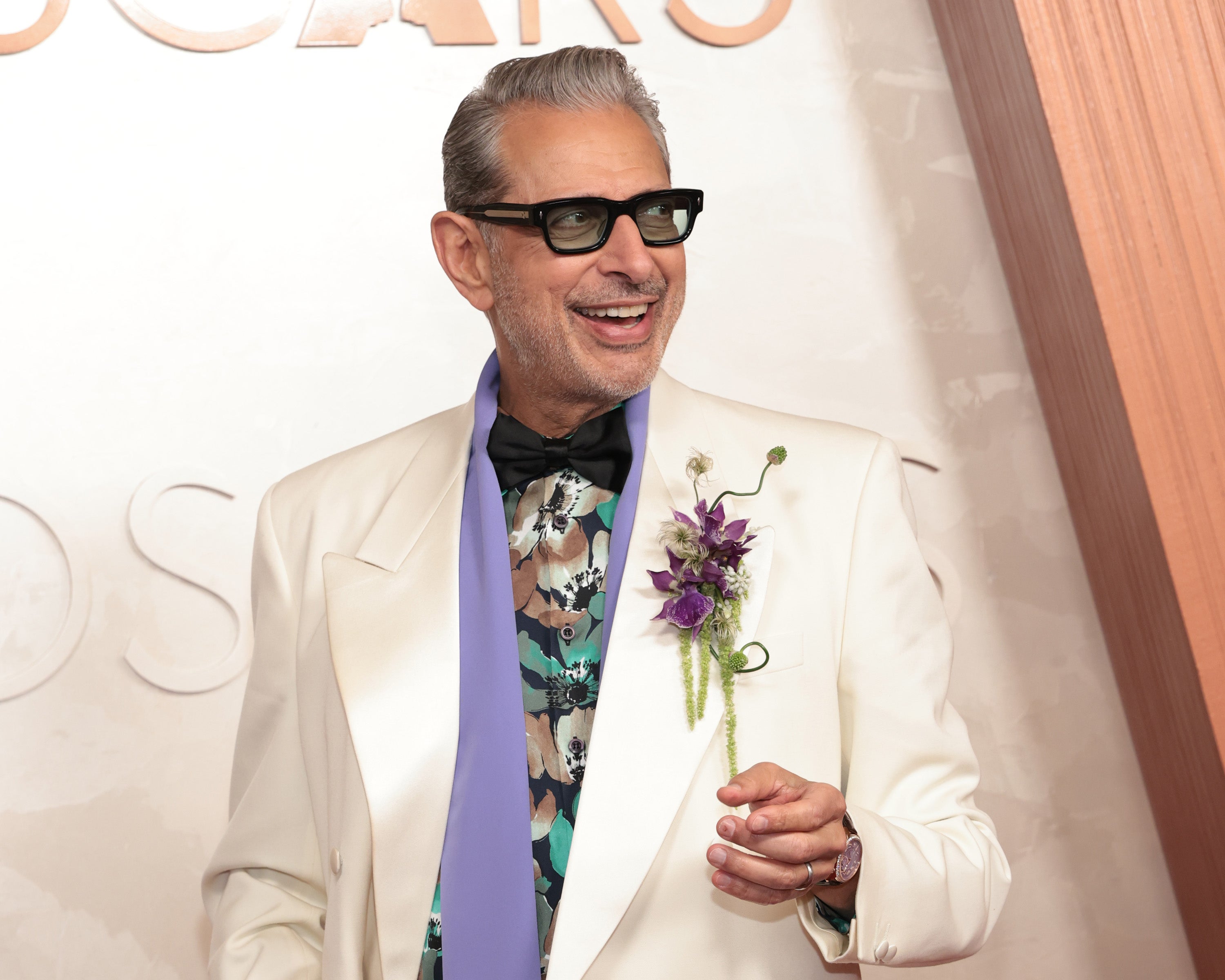 Goldblum walked the red carpet wearing a white suit jacket with black pants and a few lavender and green accents that some people didn’t think landed