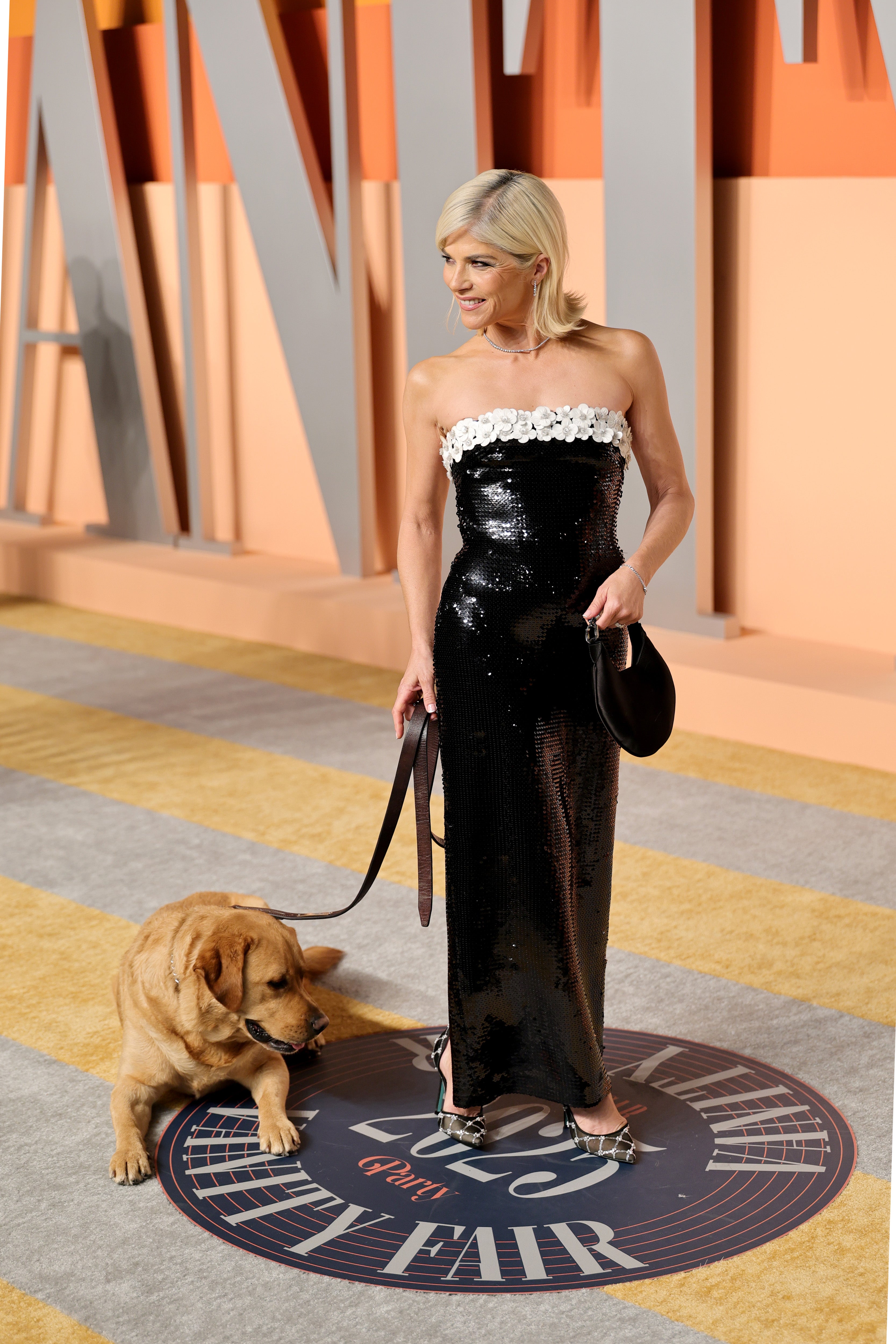 Selma Blair showed up to the star-studded after-party in a black strapless, sequin gown with a white floral trim on her neckline and an adorable dog on her arm
