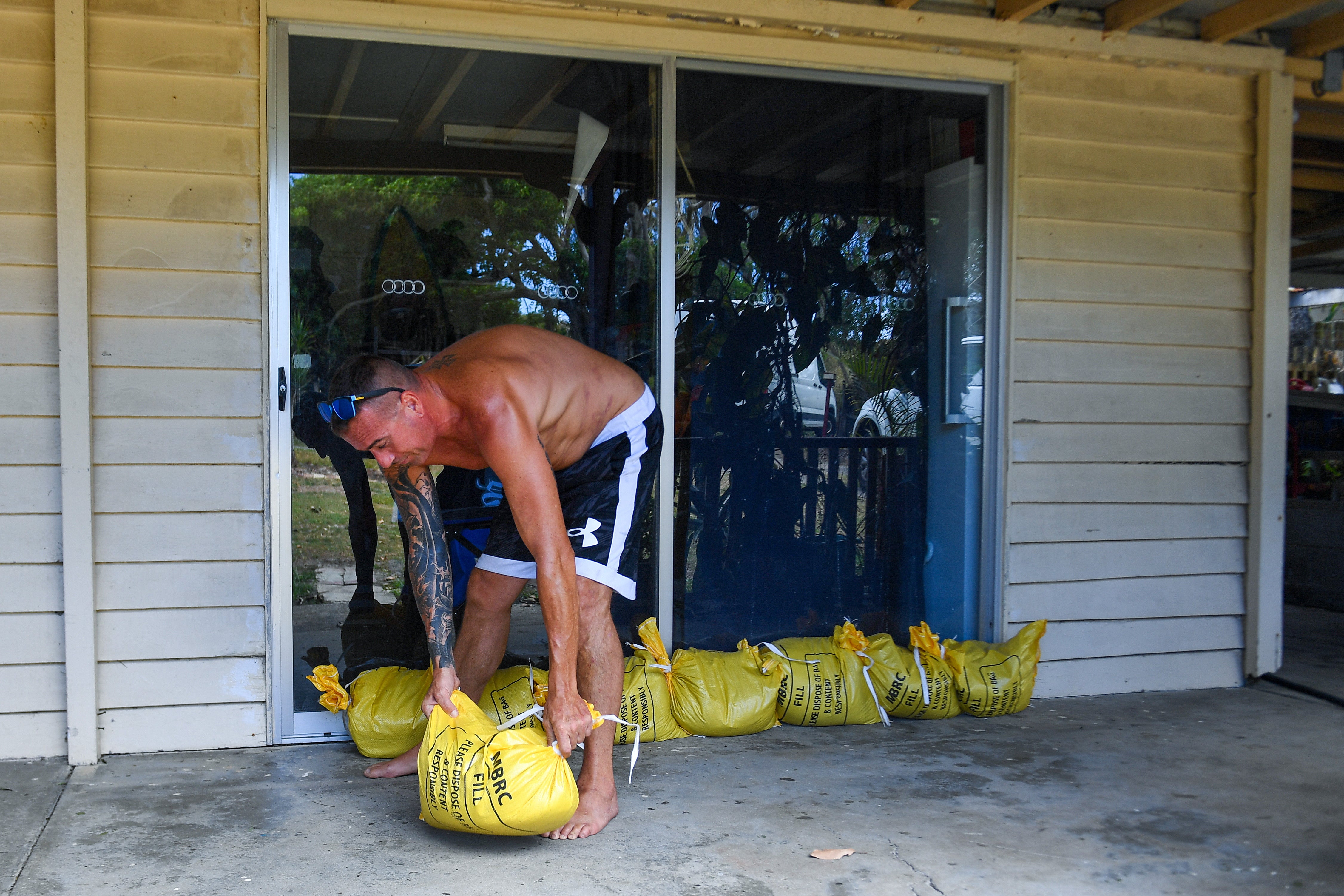 Brisbane resident Jon Wadey sandbags his house